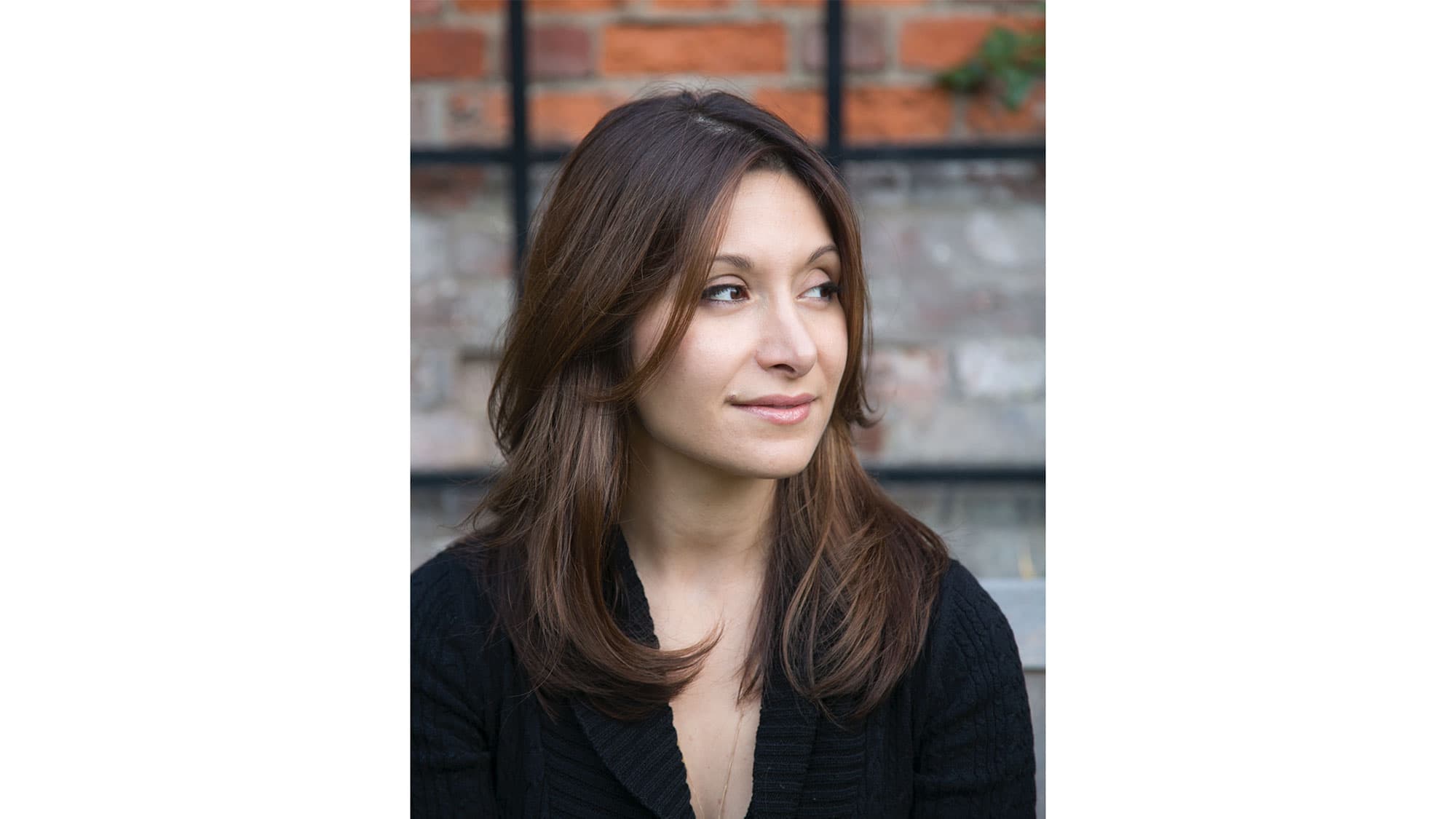 A woman wearing a black top poses for a photo.