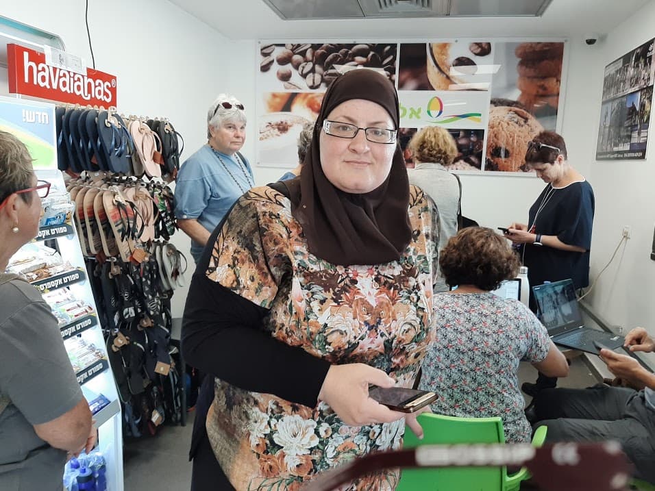 A woman stands with smartphone in a shop with organizers