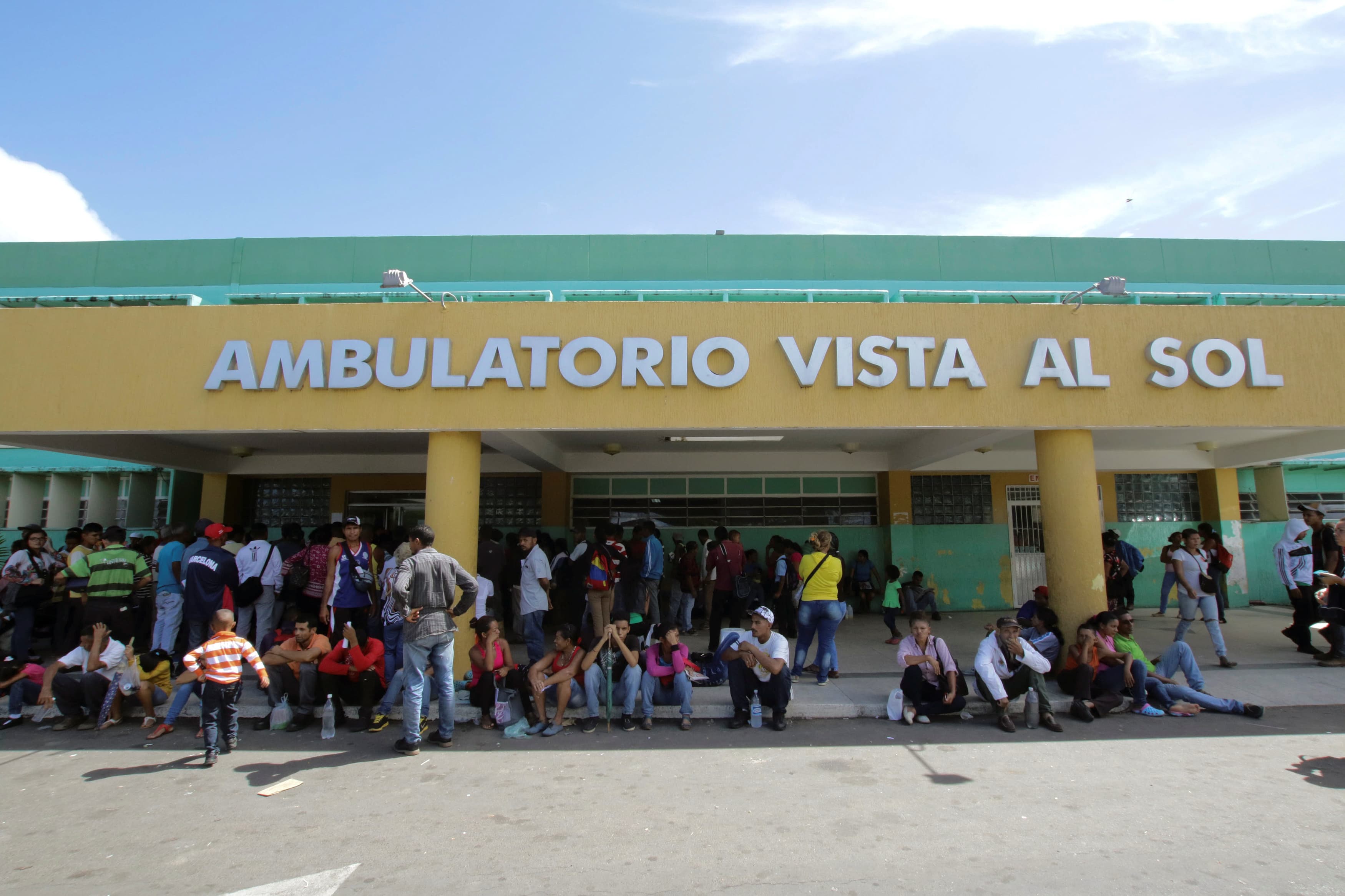 People line up outside a hospital.
