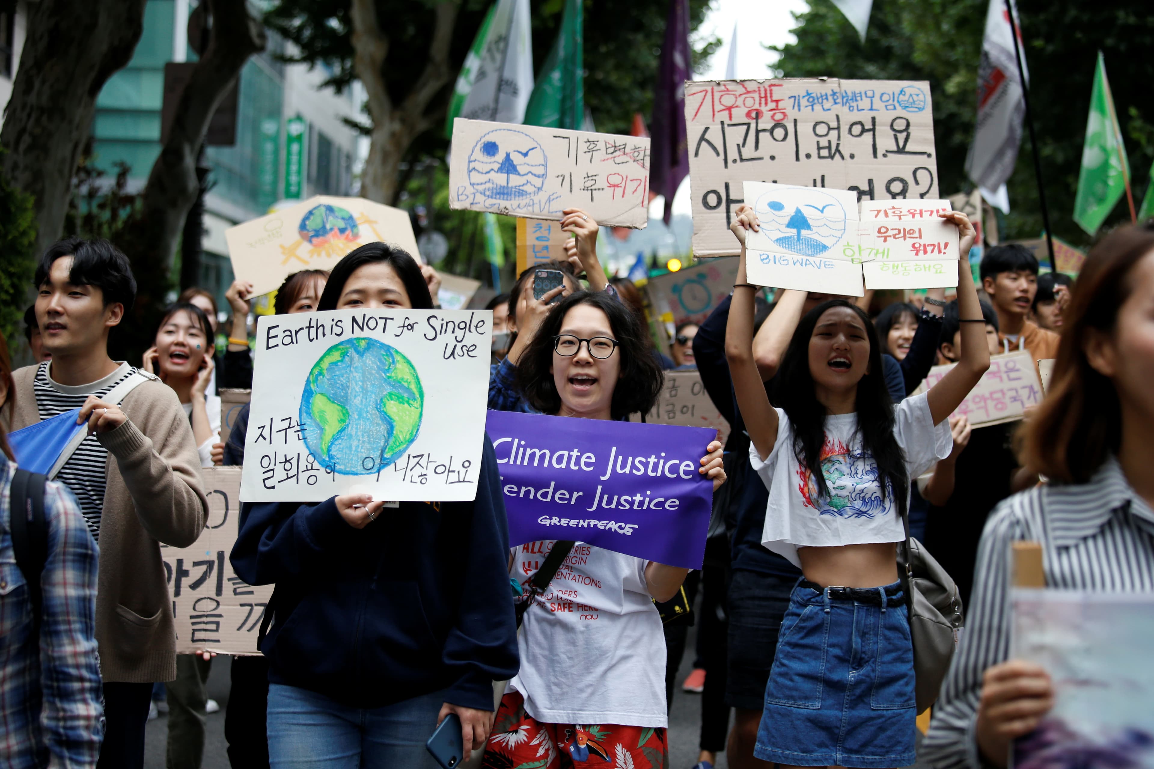 A group of young protesters hold signs and posters.