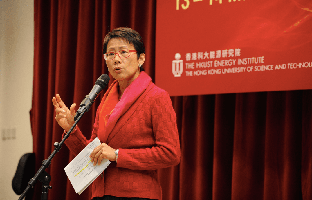 A woman in a red suit at a podium