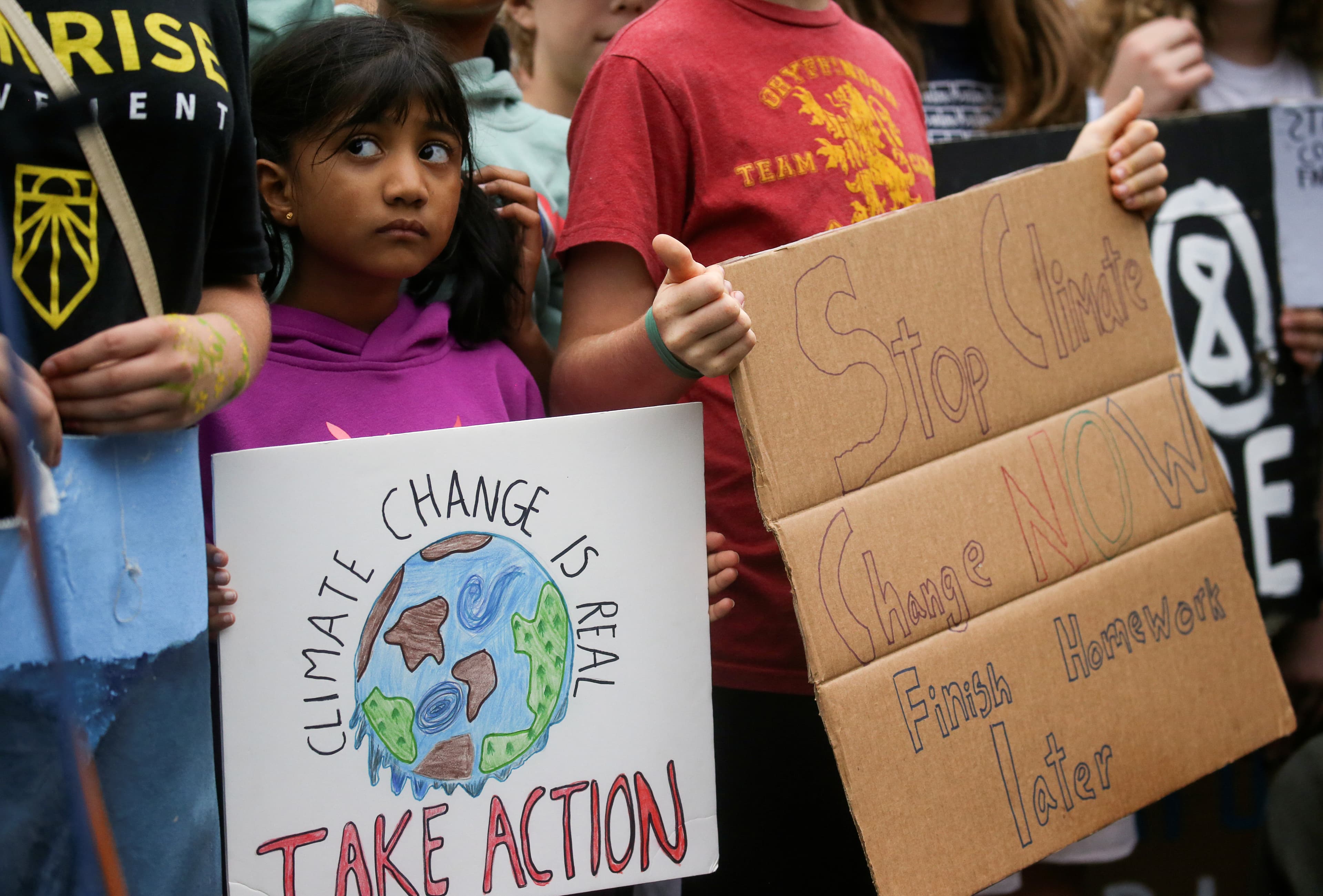 A young girl holds a sign reading 