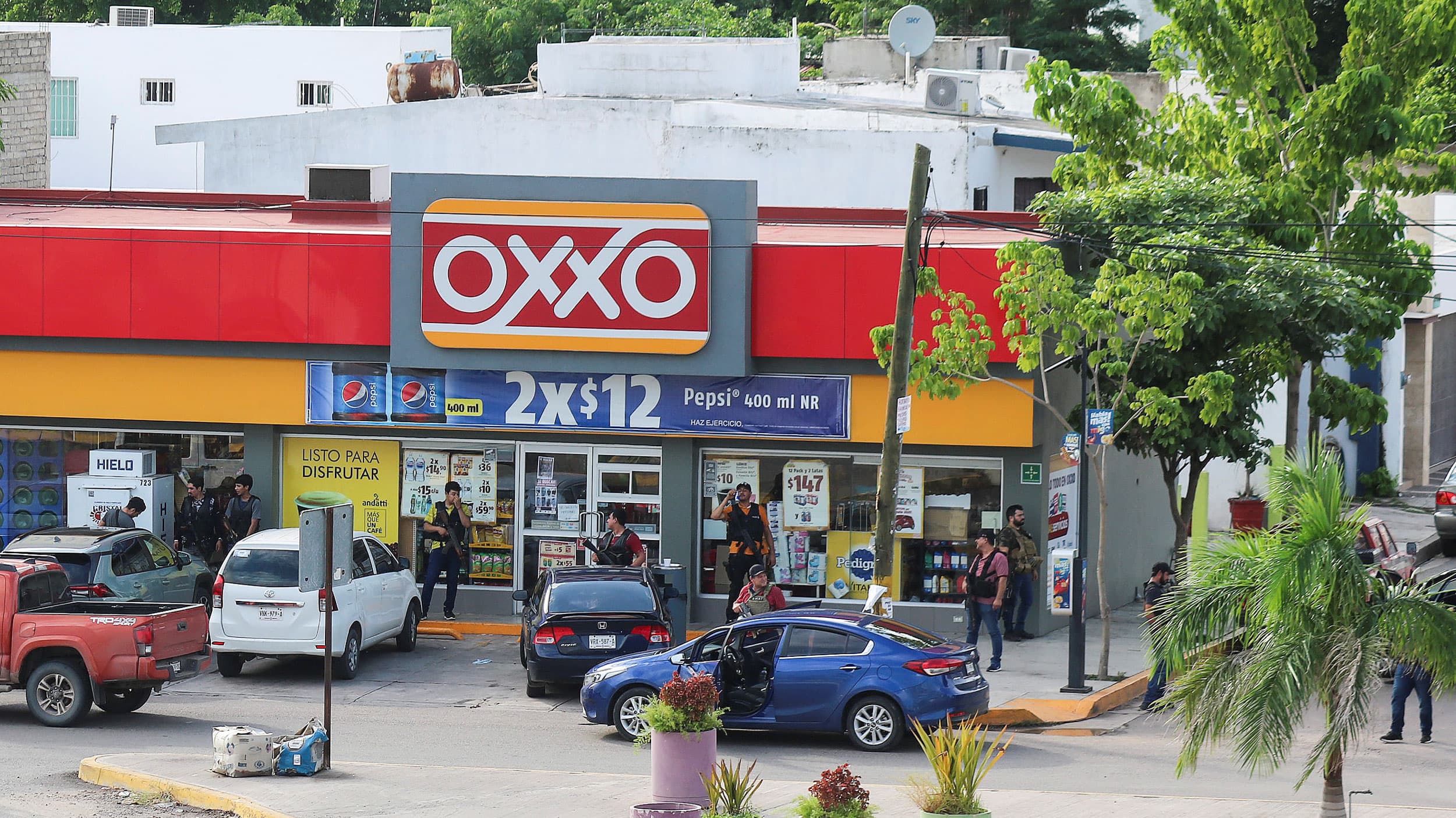 Man with guns stand outside a convenience store