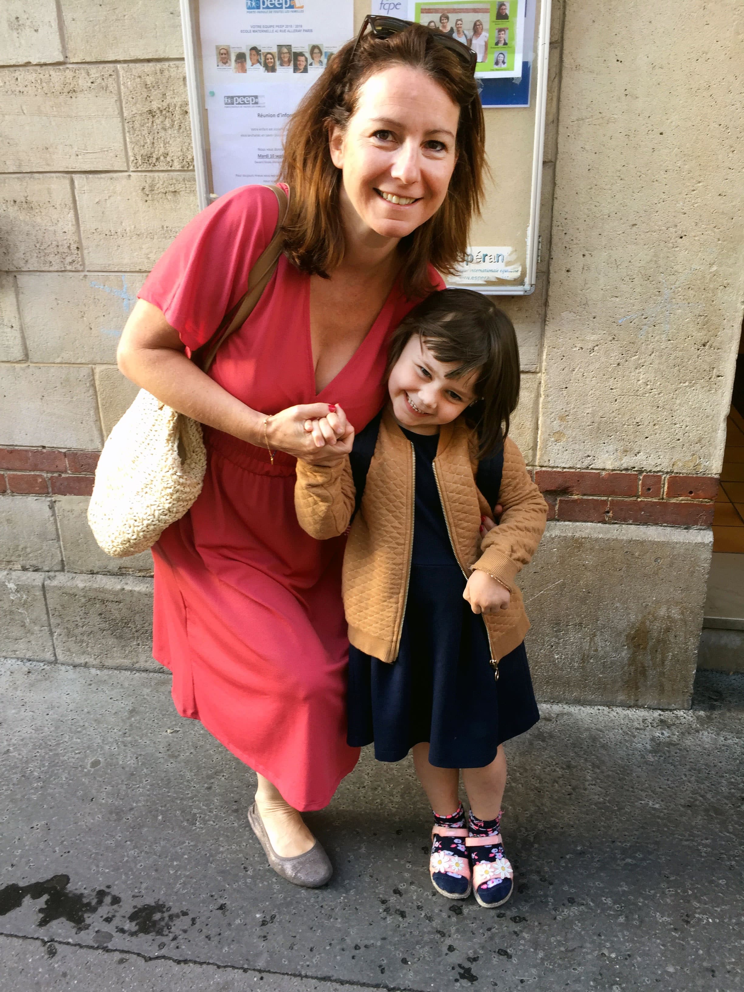 A woman poses for a photo with a young girl, her daughter