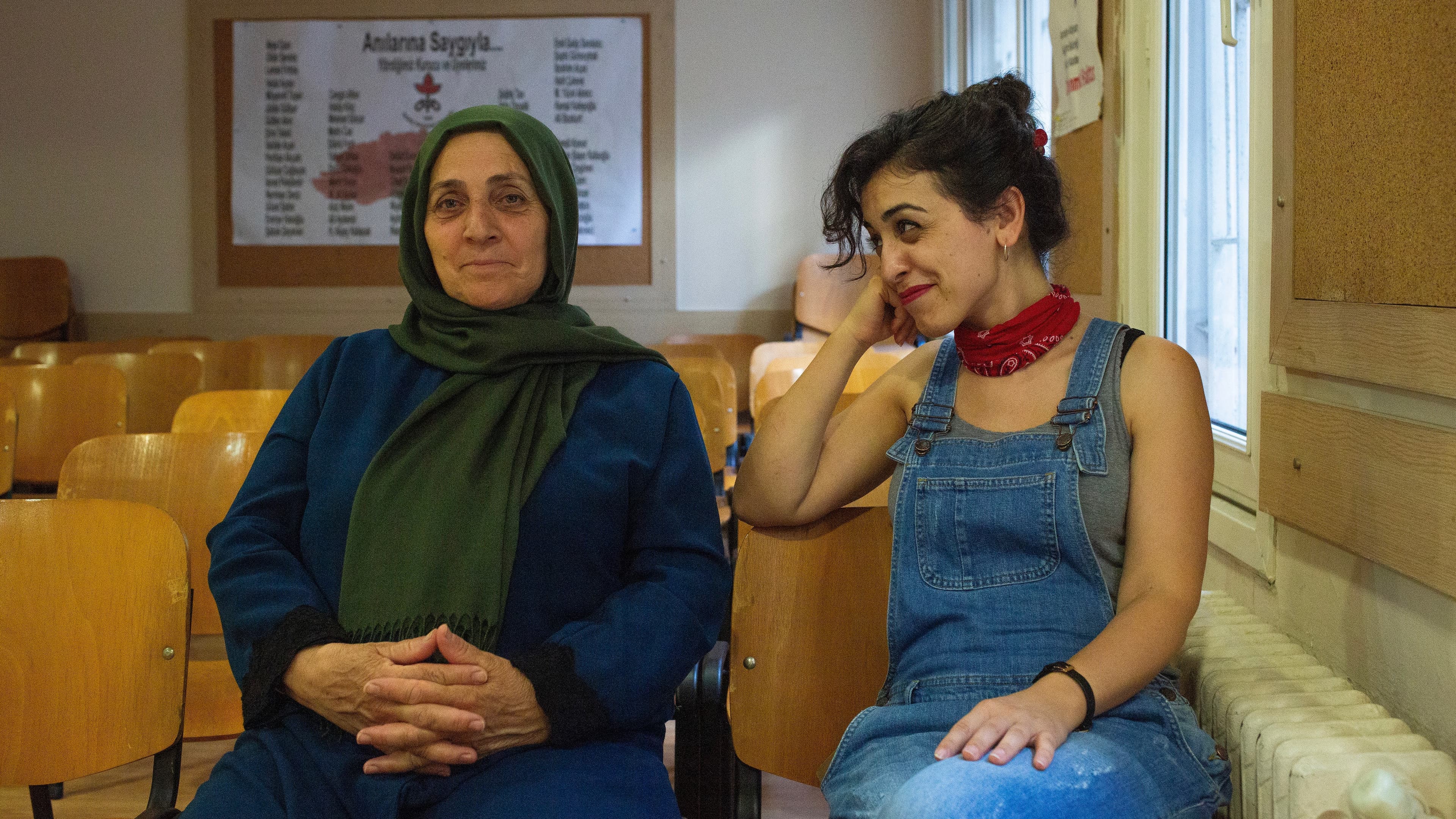 A mother and daughter sit together on a couch. They are both part of the Saturday Mothers group.