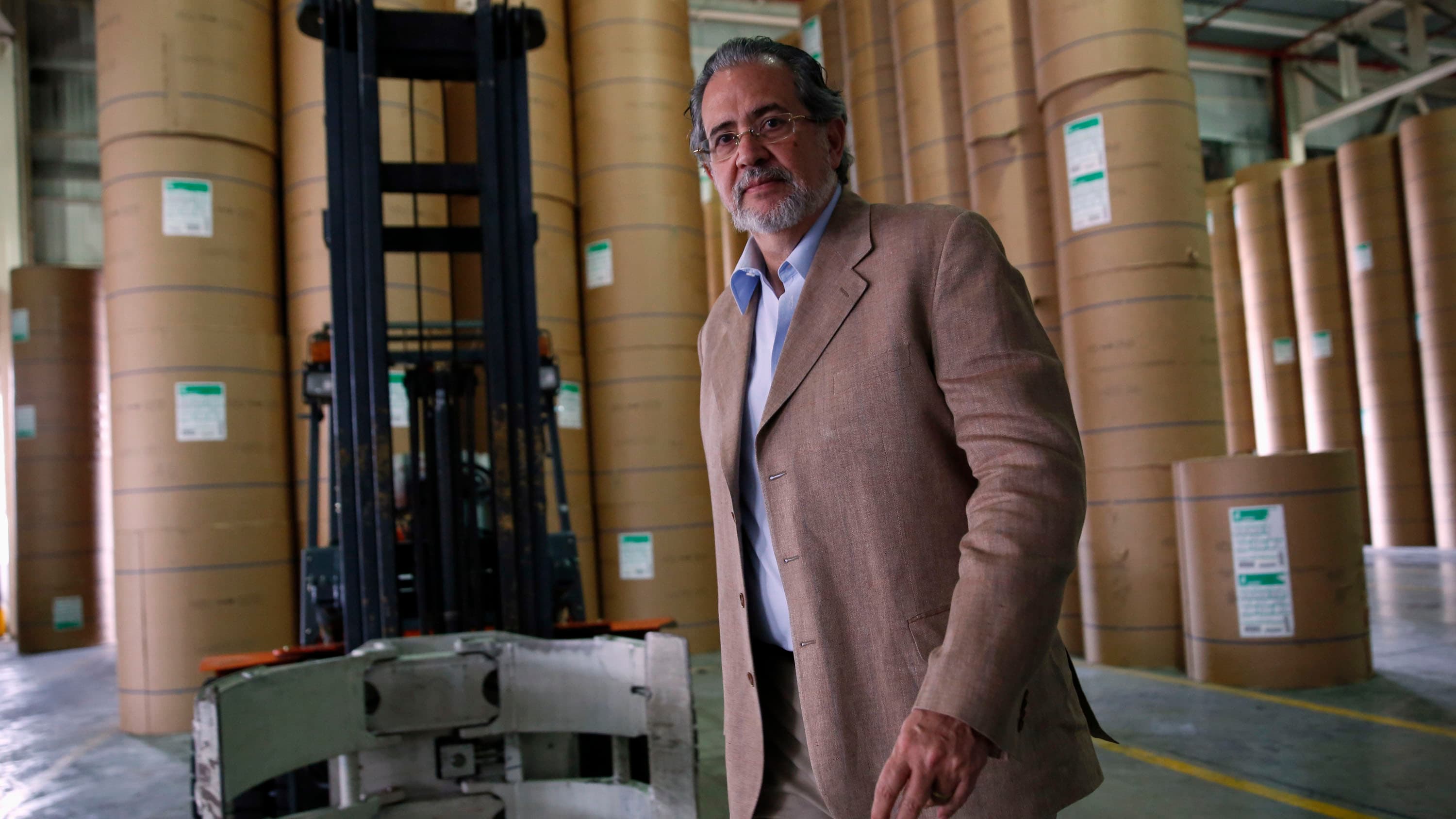 Miguel Henrique Otero, editor and president of El Nacional, one of Venezuela's main national newspapers, walks past paper rolls at the newspaper's building in Caracas on April 11, 2014. Since 2015 he has lived in self-imposed exile in Madrid, Spain.