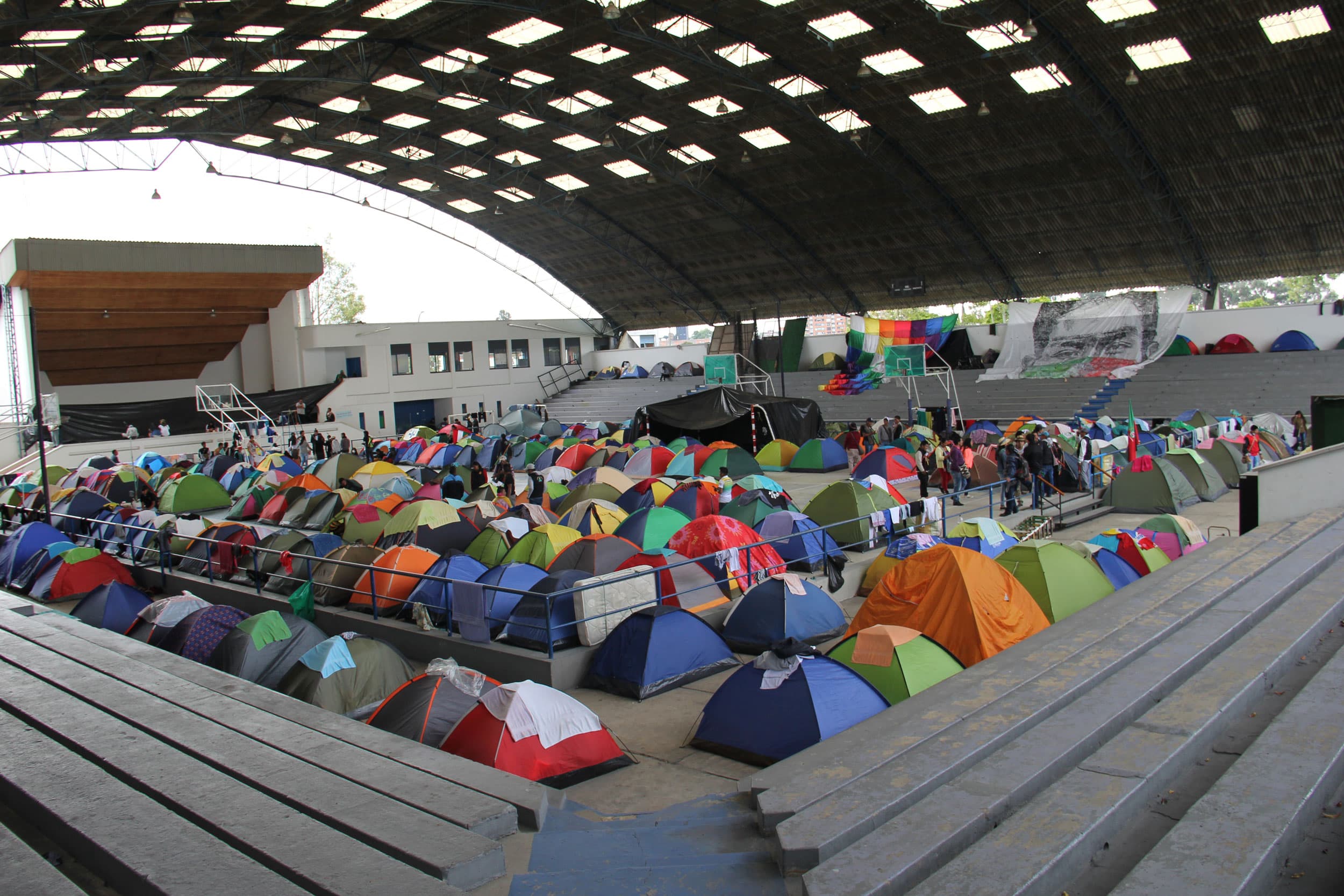 The floor of a stadium is filled with small pup tents.