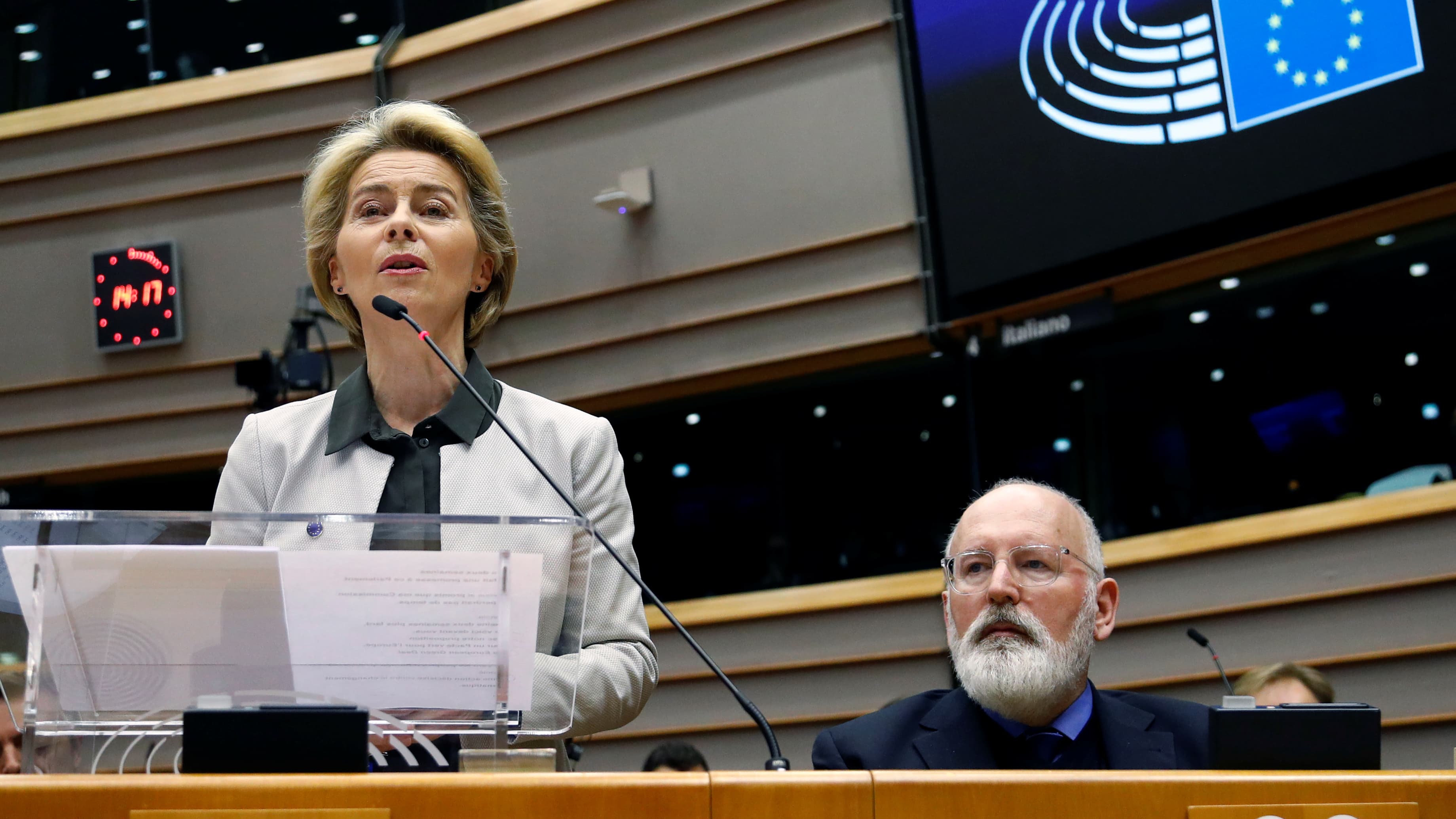 A woman stands and speaks at a podium