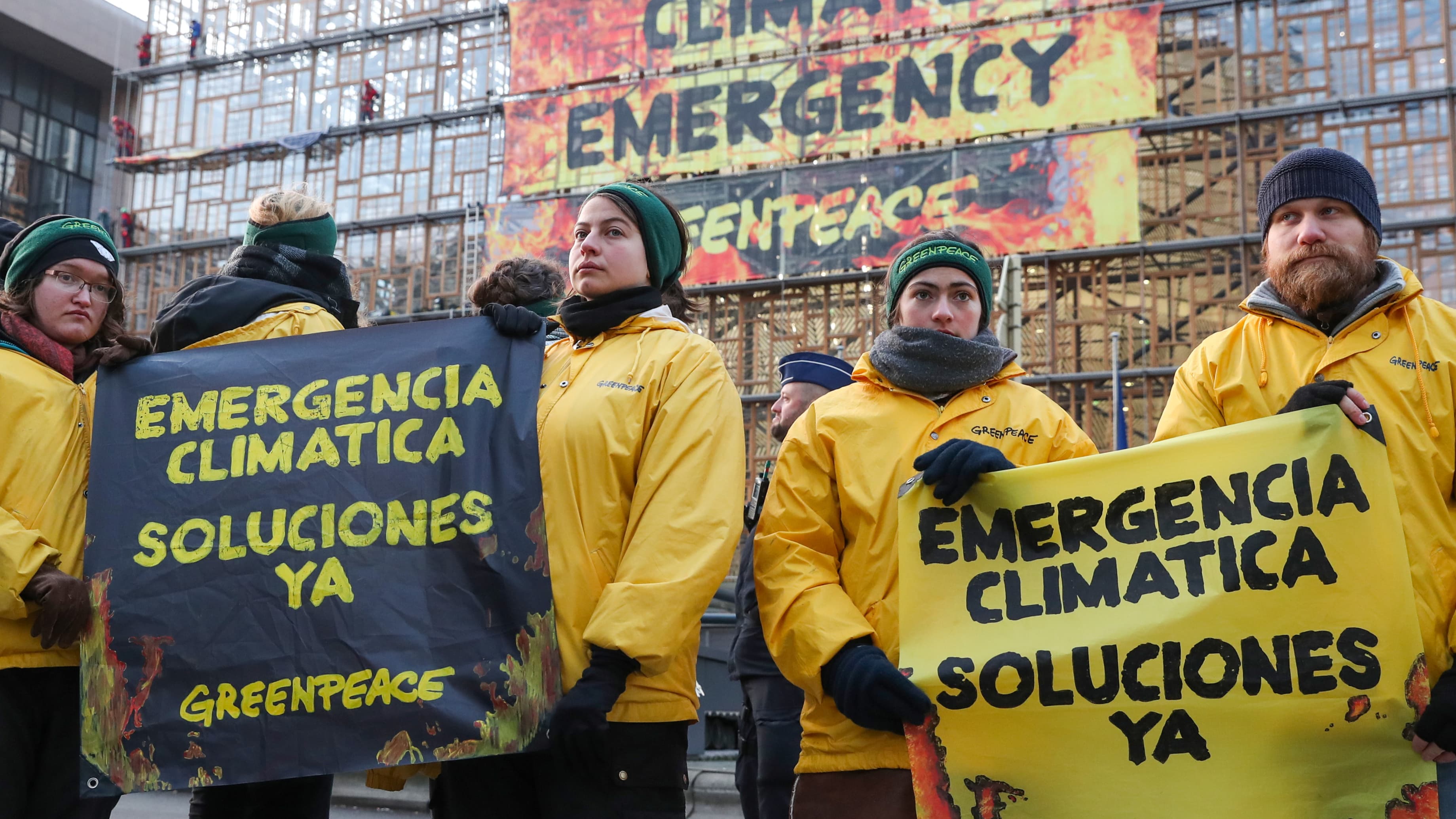 Protesters wear yellow jackets and sign that speak of climate emergency in Spanish language