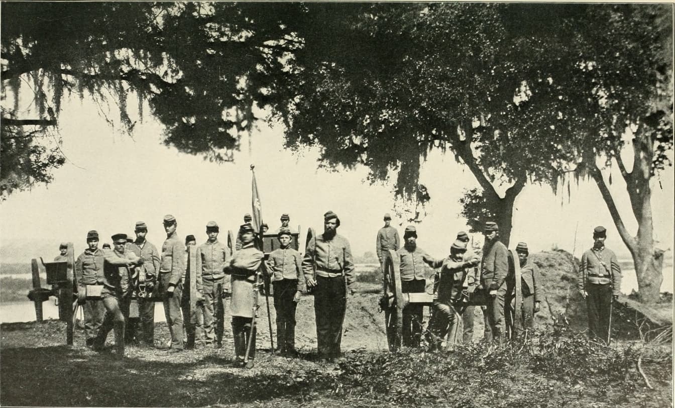 A group of military men stand in a line with their weapons.