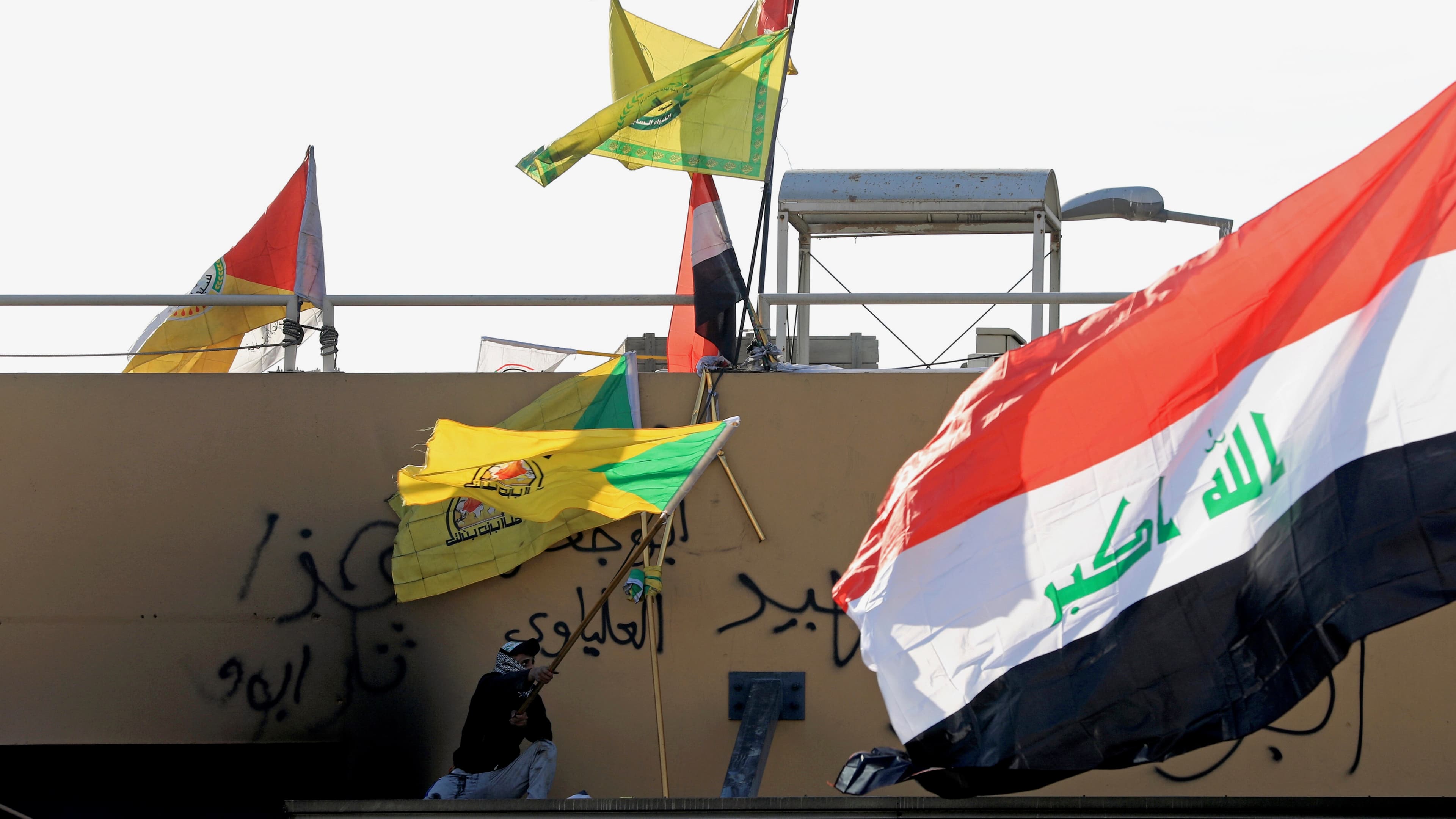A member of Hashd al-Shaabi waves a flag