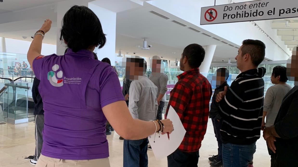 A government official talks to Mexican deportees