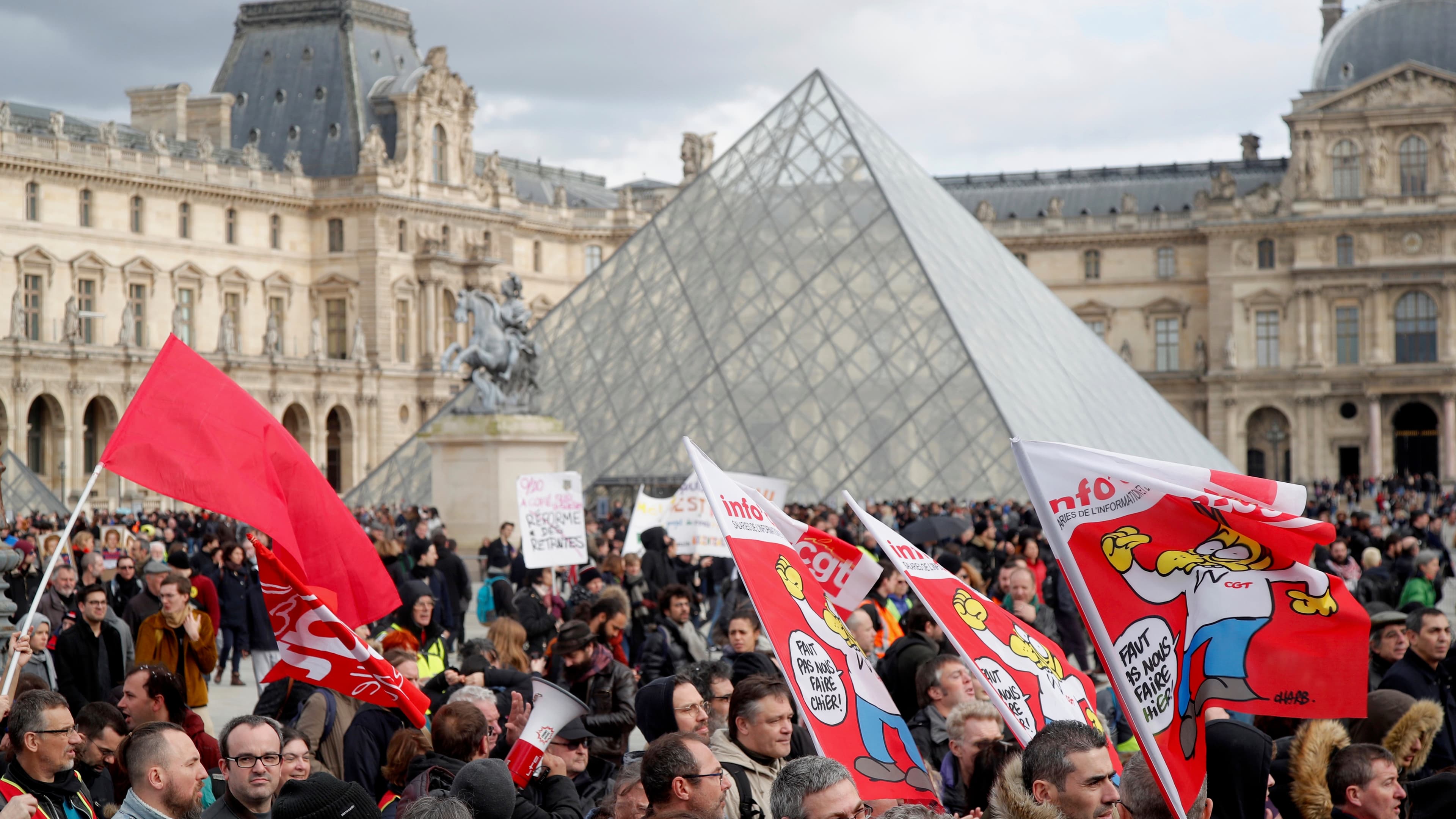 Protesters attend a demonstration in front of the glass pyramid of the Louvre museum before the opening debate on the French government's pensions reform bill at the National Assembly in Paris, Feb. 17, 2020.