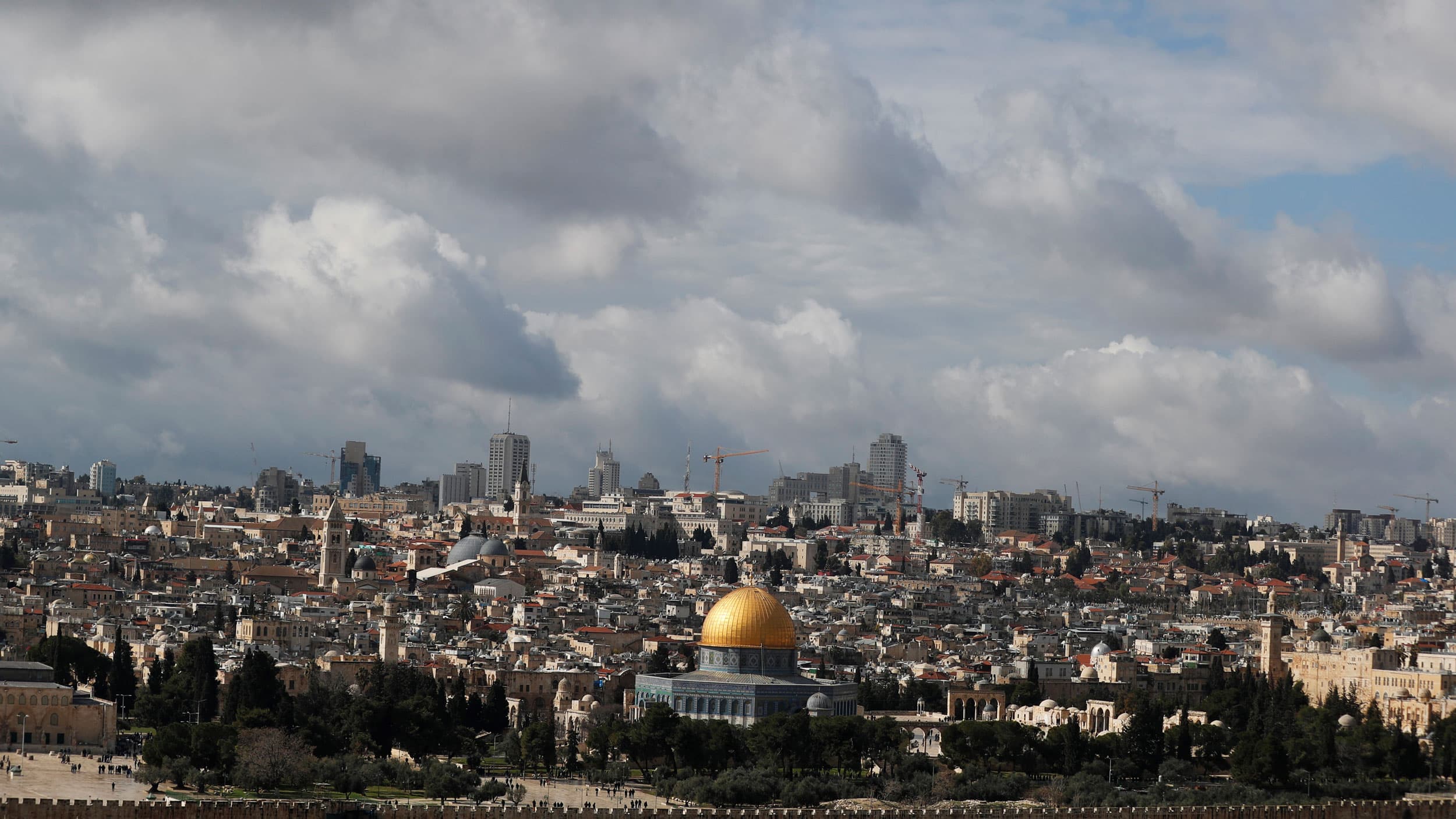 The Dome of the Rock is shown in the distance in a wide framed photograph of Jerusalem's Old City.