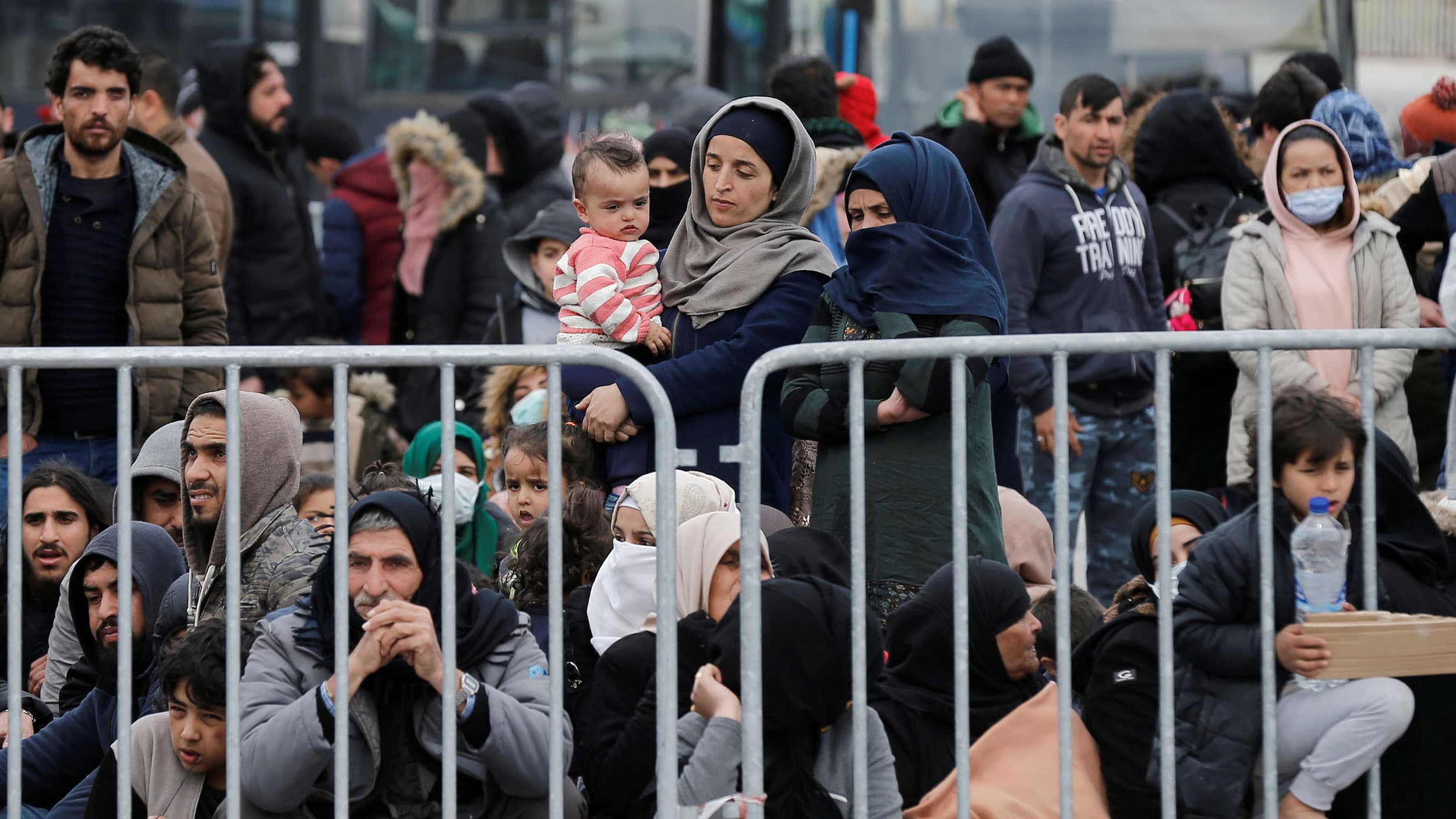 A group of people behind a metal barrier