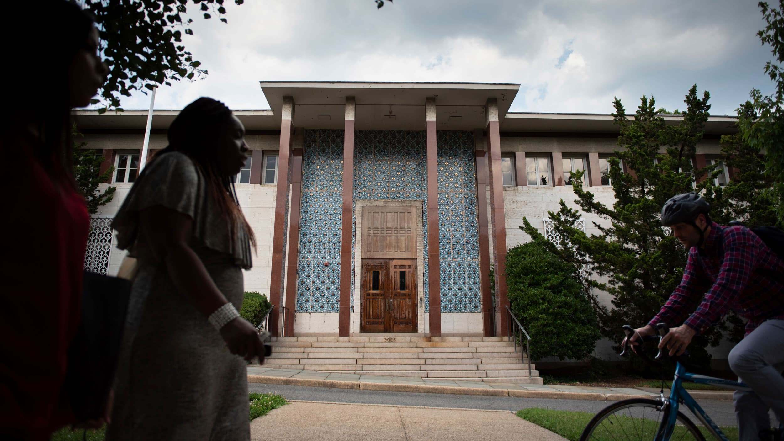 A bicyclist rides past the front entrance of the former Embassy of Iran.