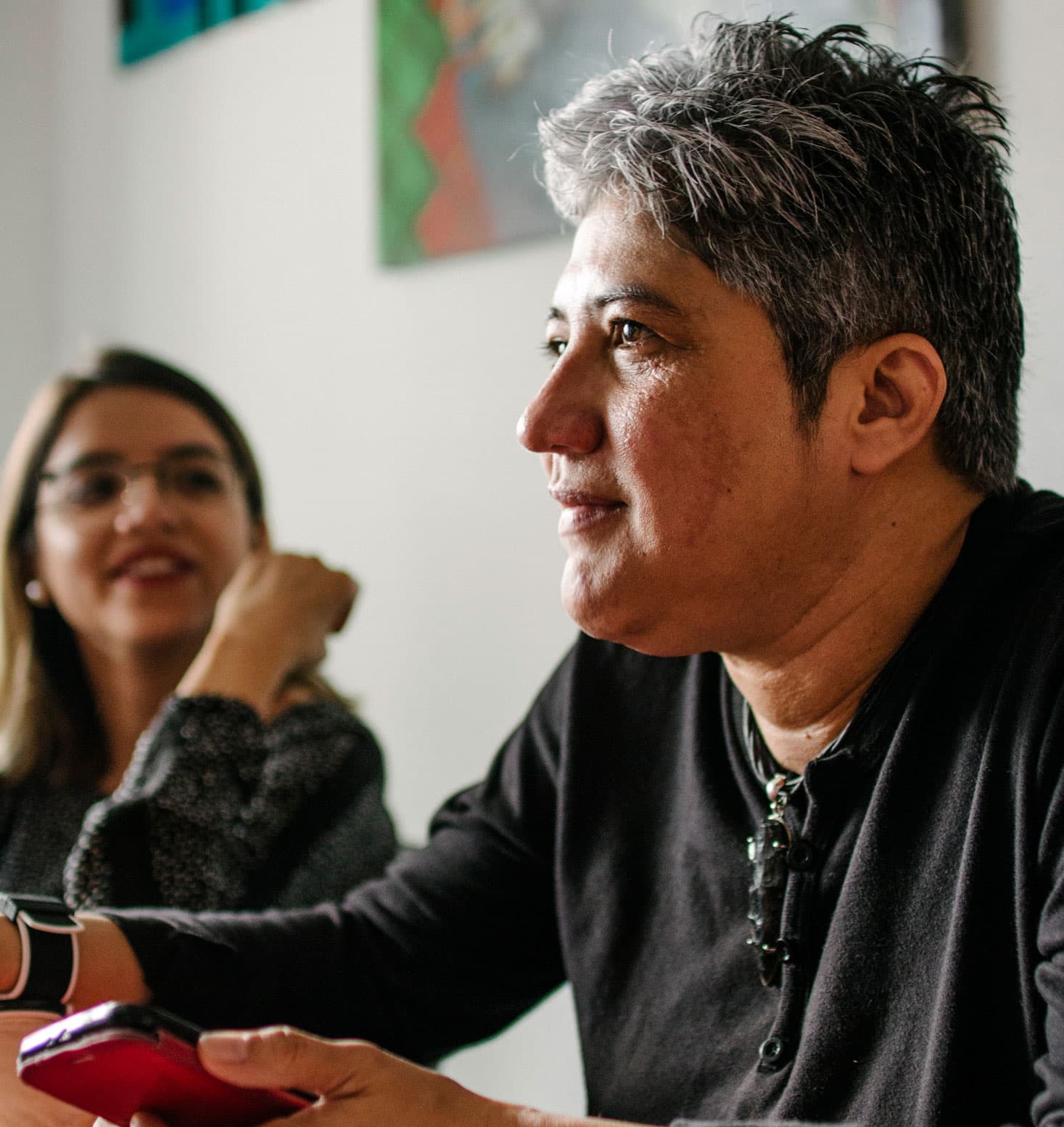 Indyra Mendoza is shown with a dark shirt on and holding a phone.