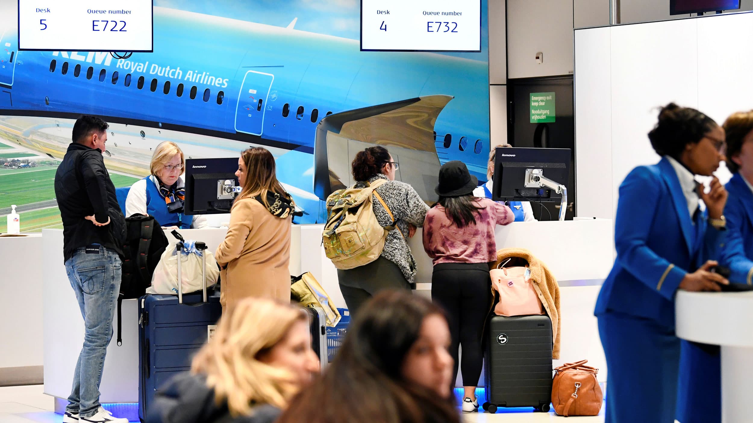 Several people are shown standing at airport service desk with their luggage nearby.