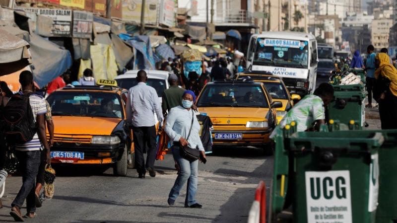 A woman wears a face mask, due to the global coronavirus disease (COVID-19) outbreak, as she walks along a busy shopping street in Dakar, Senegal, March 18, 2020.