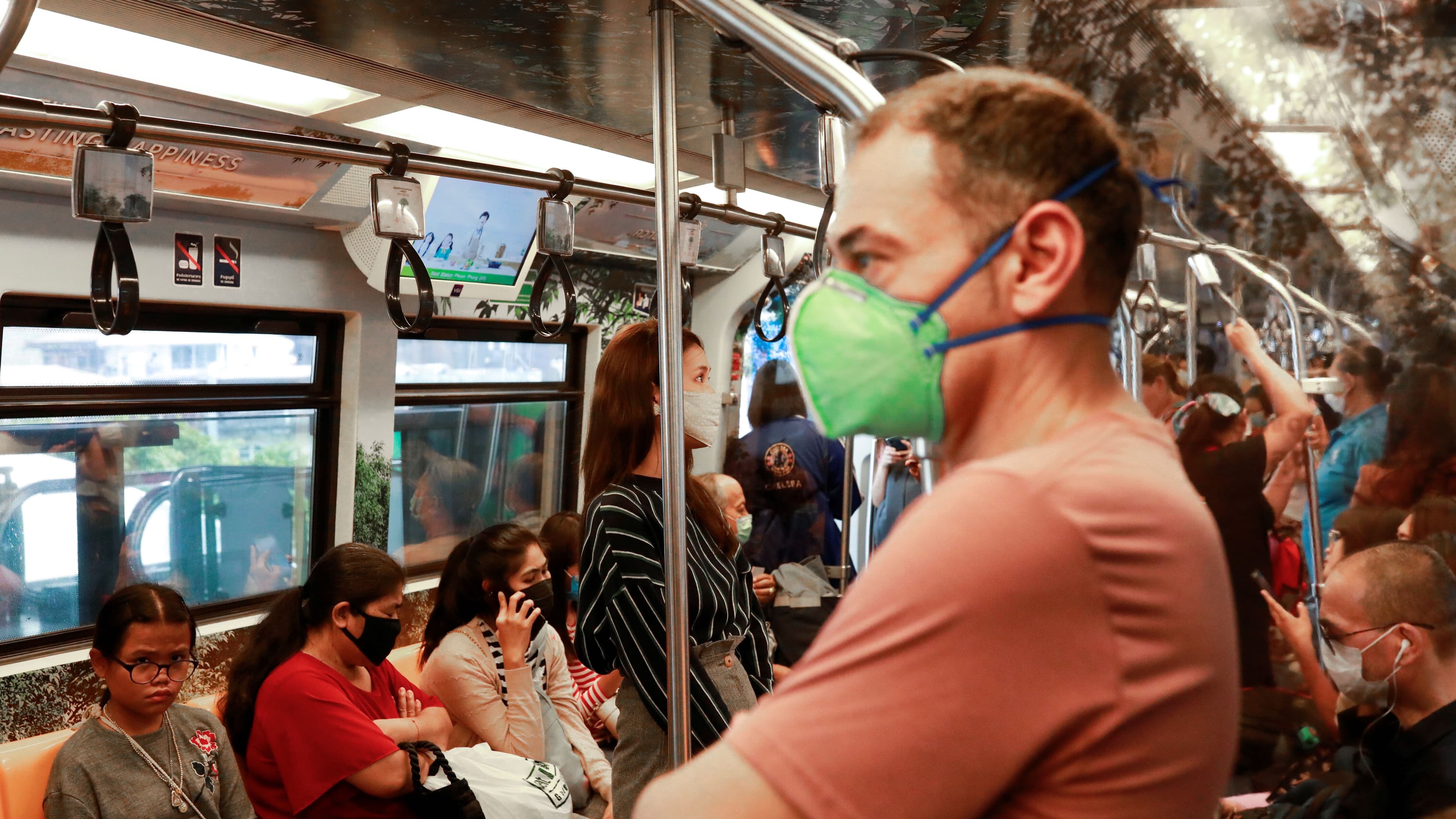 Passengers wear protective masks due to the coronavirus outbreak on a train in Bangkok, March 16, 2020.