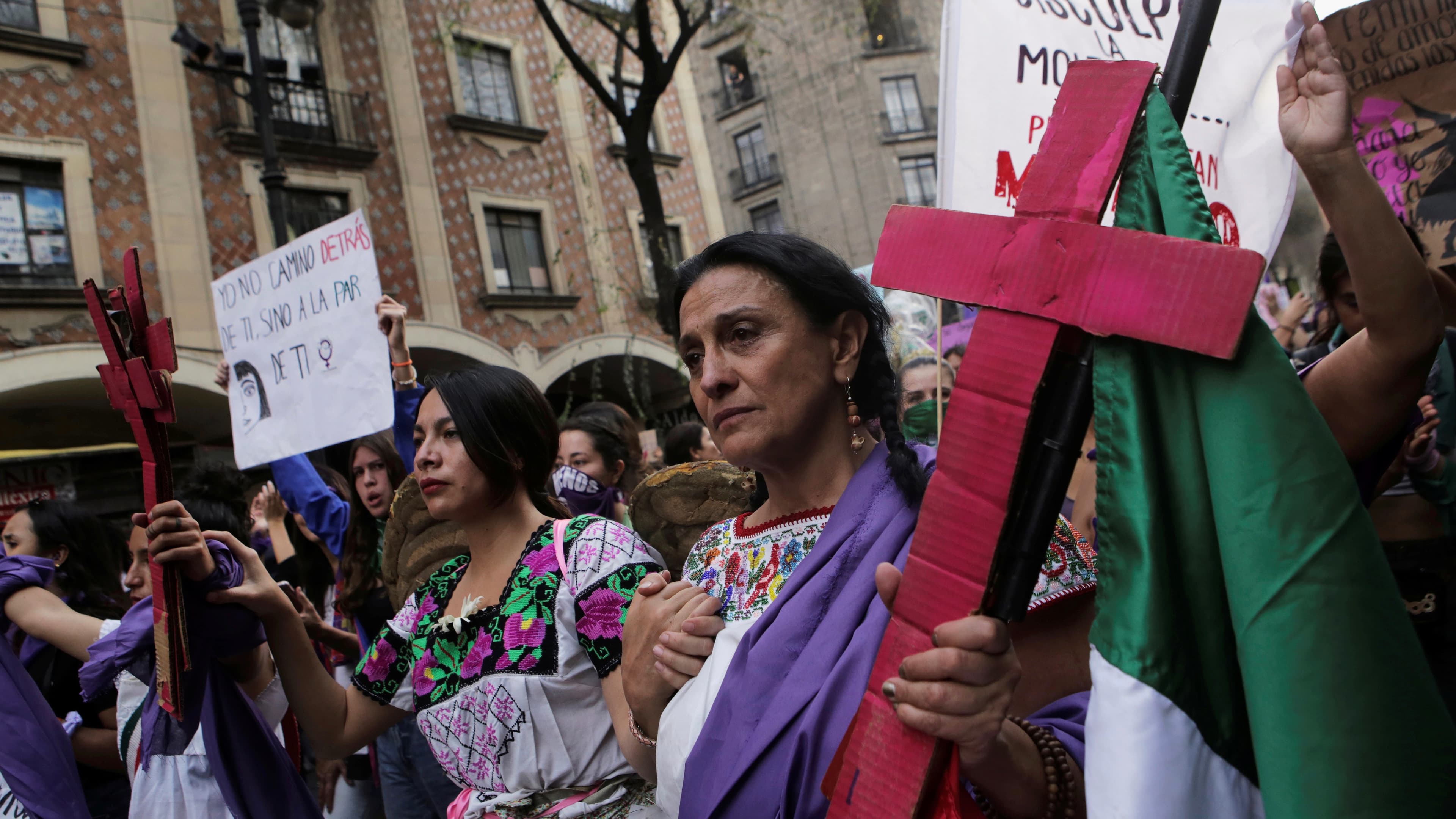 A woman holds a pink cross during a protest to mark International Women's Day at Zocalo square in Mexico City, Mexico, March 8, 2020.