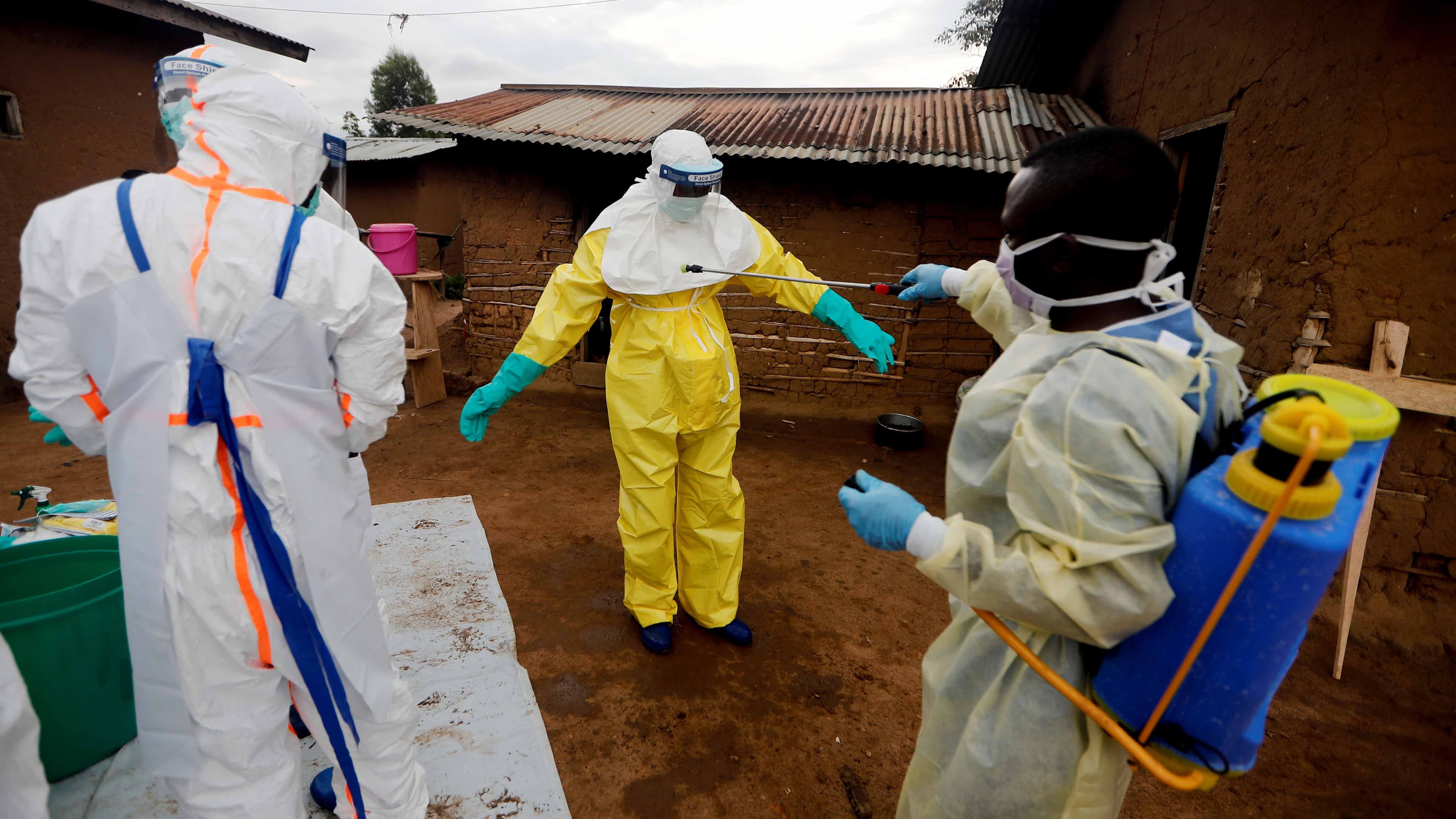 A health care worker who volunteered in the Ebola response, decontaminates his colleague after he entered the house of a woman suspected of dying of Ebola, in the eastern Congolese town of Beni in the Democratic Republic of the Congo, October 2019.