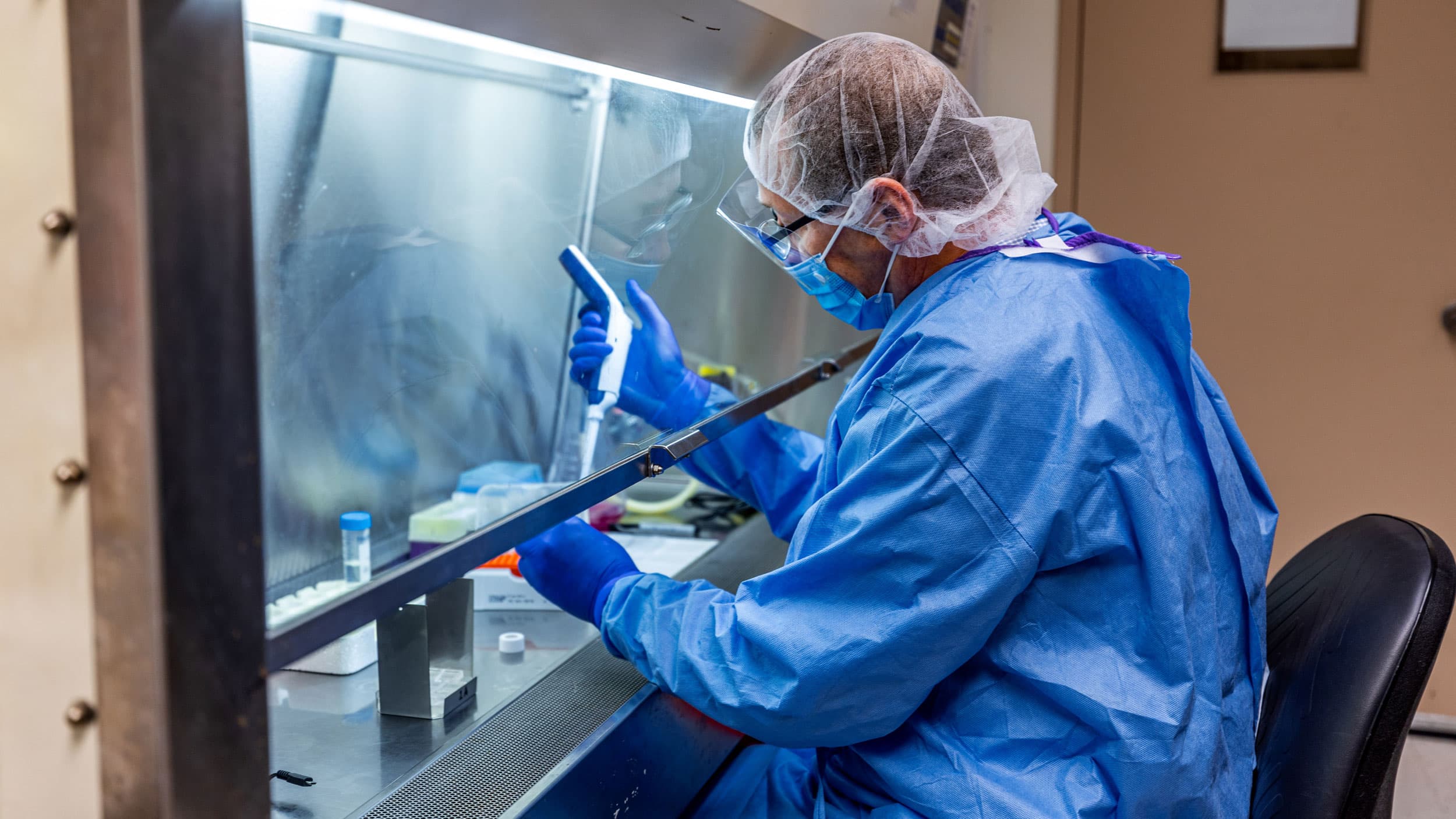 A researcher in PPE in a lab