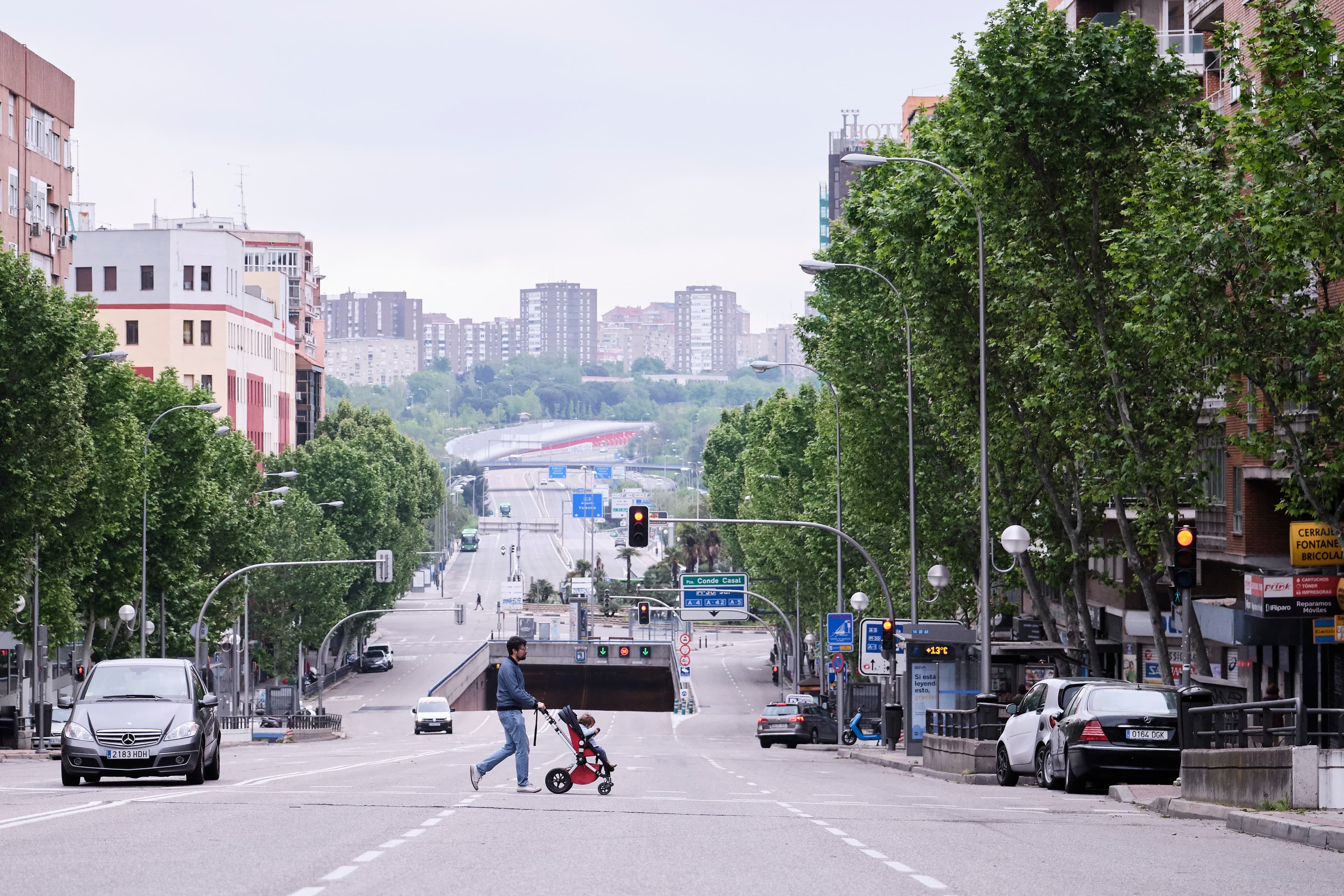 A man walks a baby across the street in a pushchair in Madrid as Spain lifts restrictions on children outdoors due to the coronavirus pandemic. 