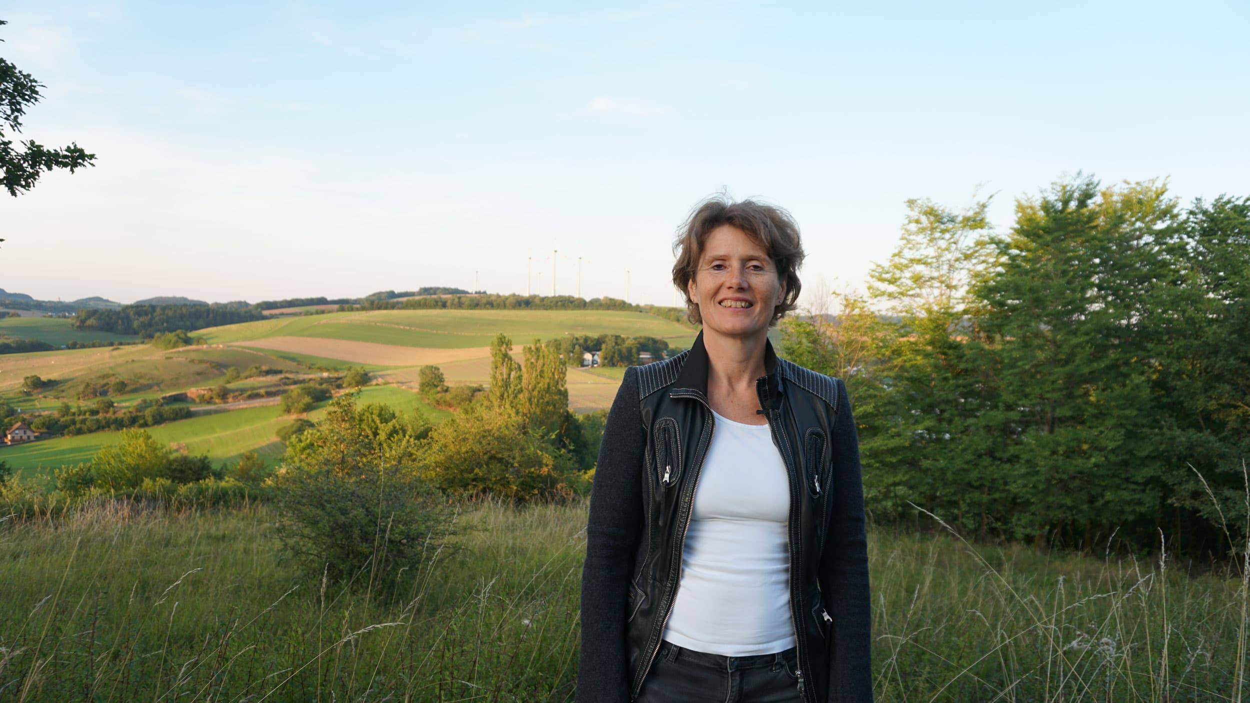 A woman stands in front of a field