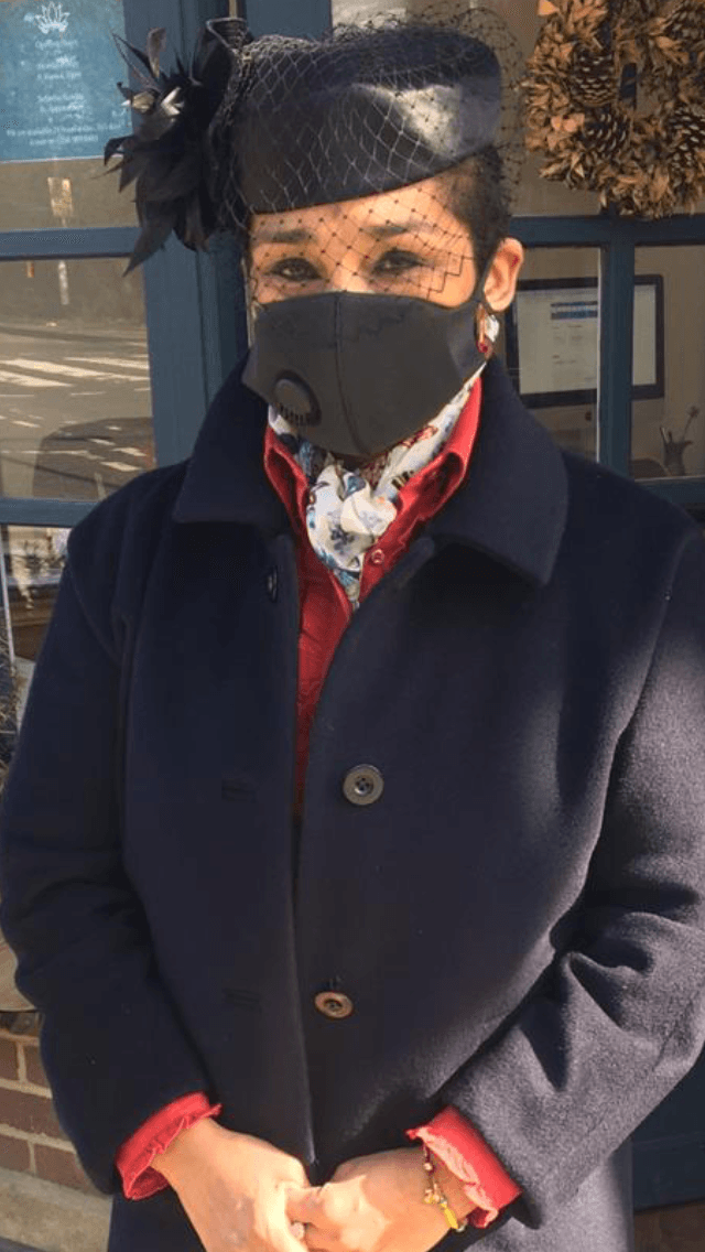 A woman in black with a face mask