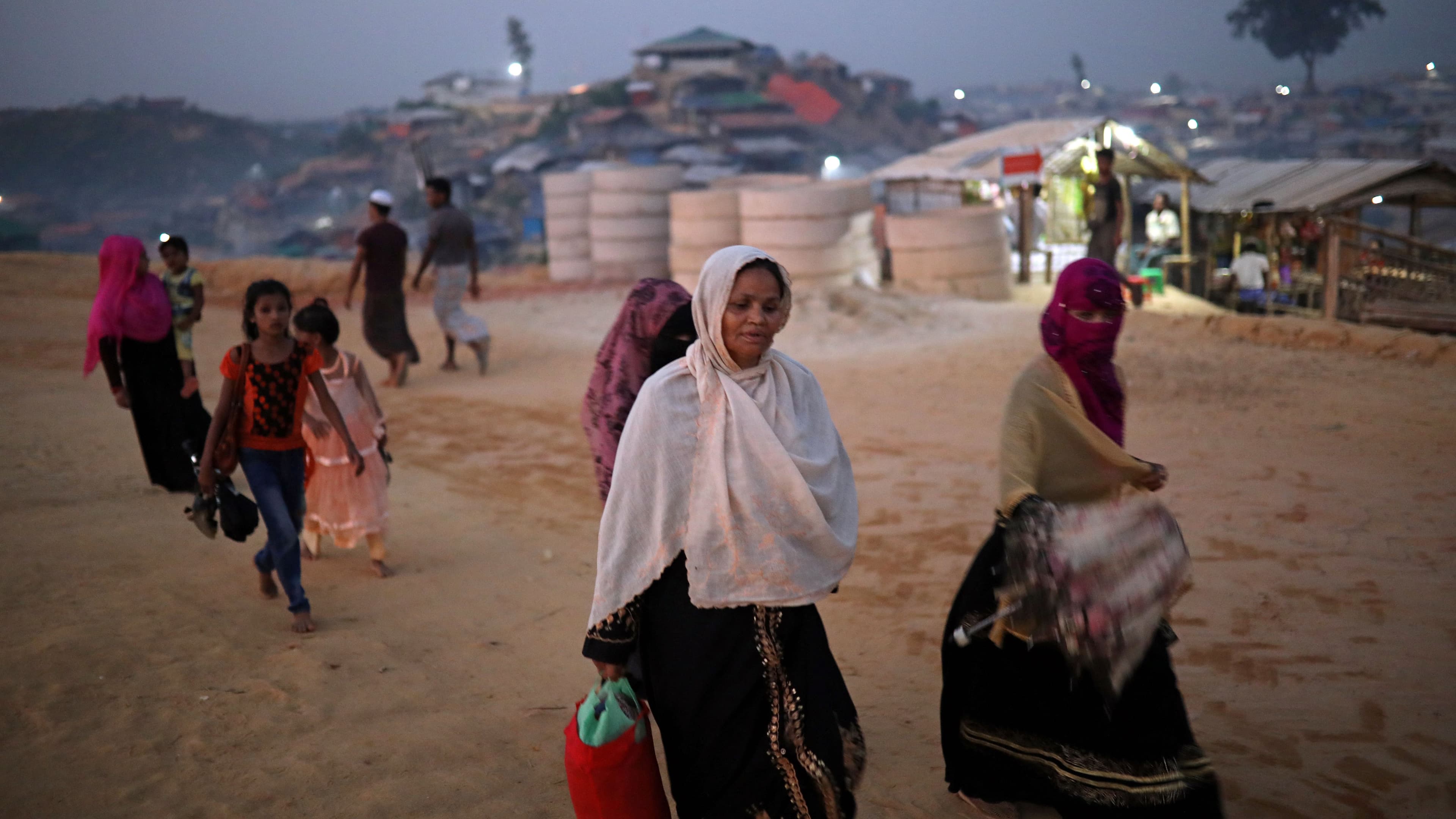 Rohingya refugees walk along the road in the evening at Balukhali camp in Cox’s Bazar, Bangladesh, Nov. 16, 2018. 