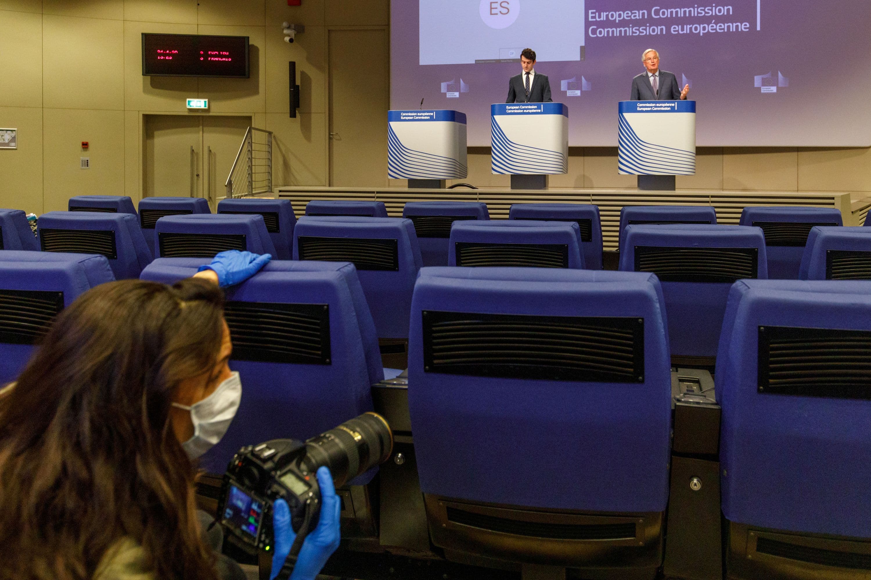 EU's Brexit negotiator Michel Barnier gives a news conference after Brexit negotiations, as a photographer wearing a mass passes by in the foreground, in Brussels, Belgium, on April 24, 2020.