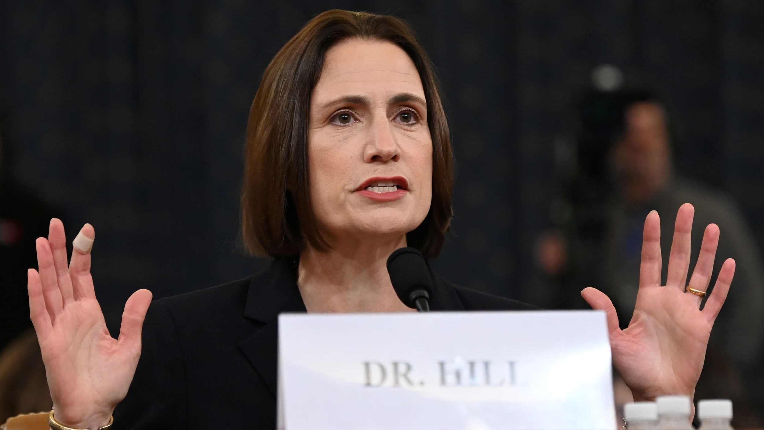 A woman behind a desk speaks