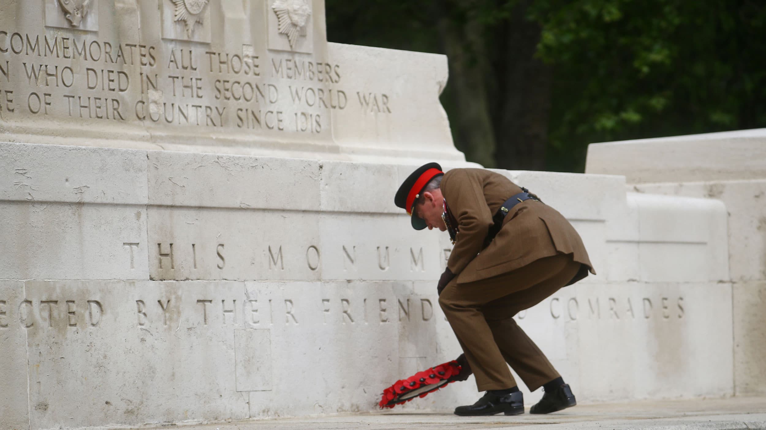 A officer lays a poppy wreath