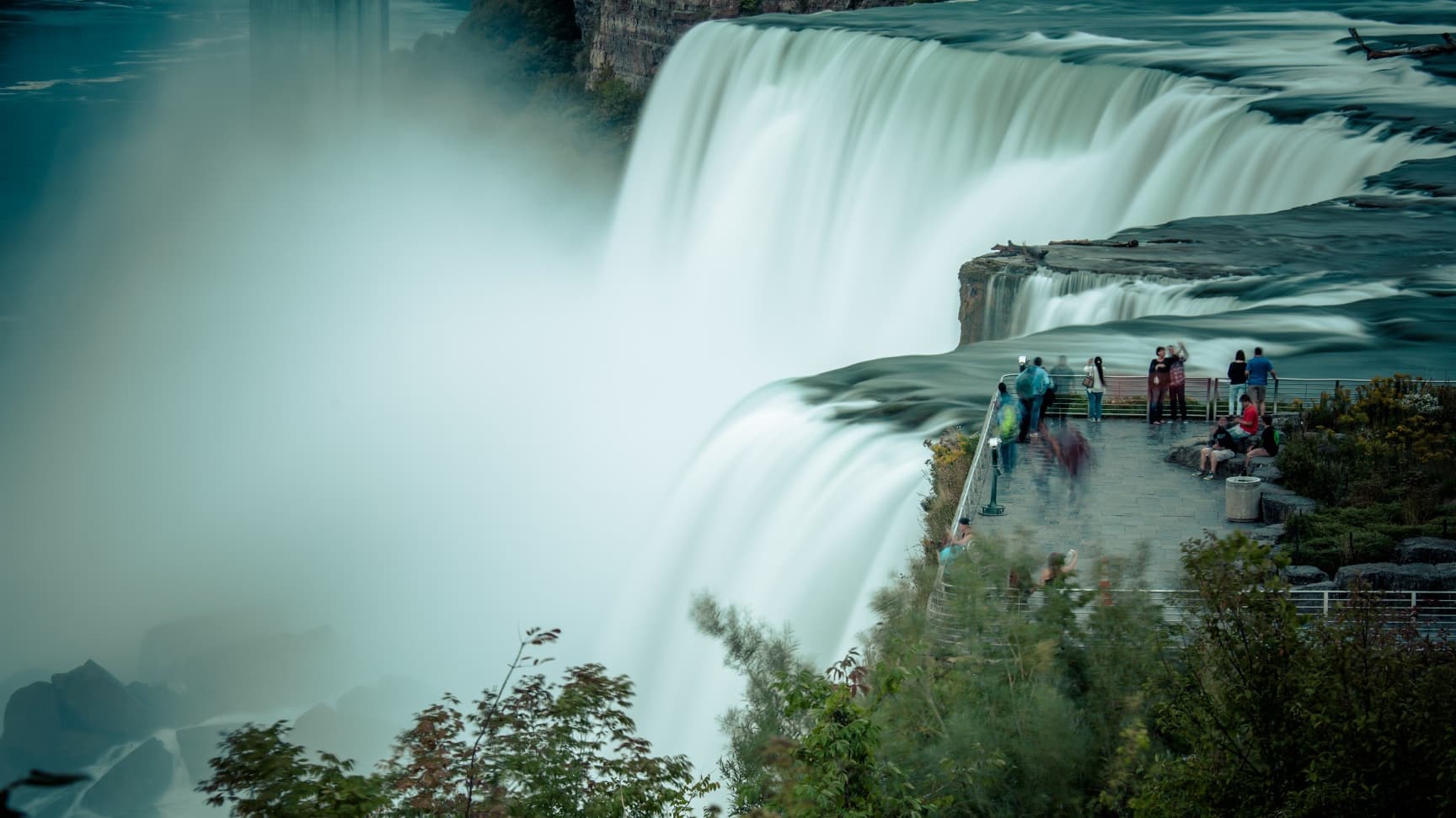 Niagra Falls waterfall with a few tourists in the distance