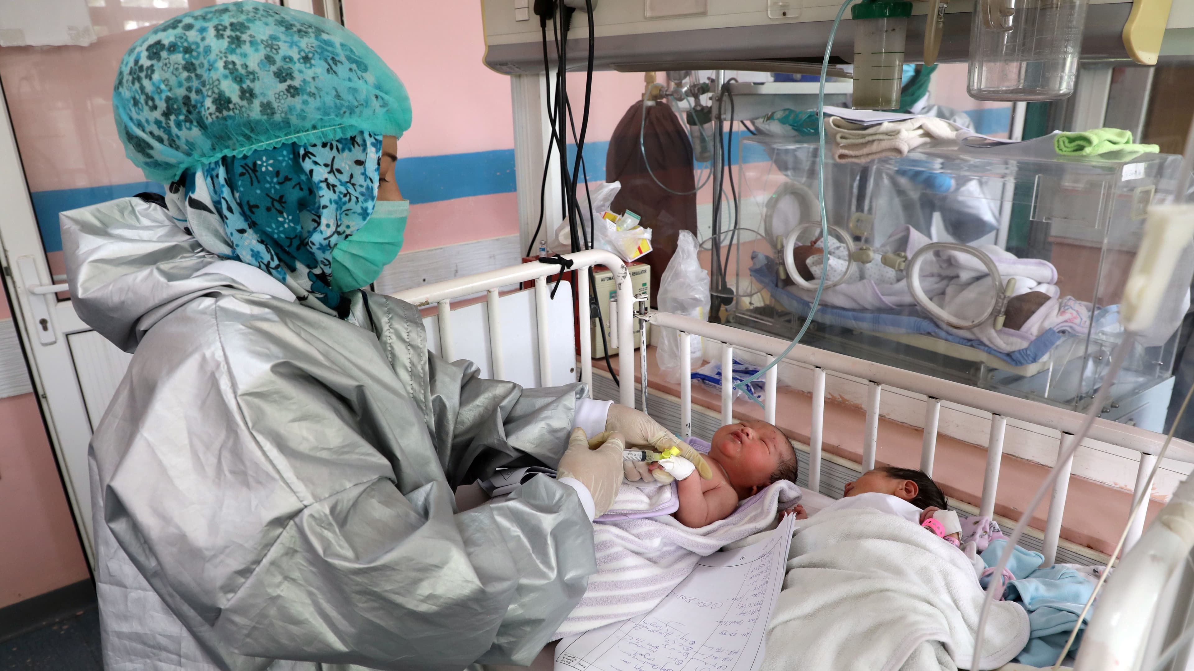 An Afghan nurse observes newborn children who lost their mothers during an attack at a hospital, in Kabul, May 13, 2020.