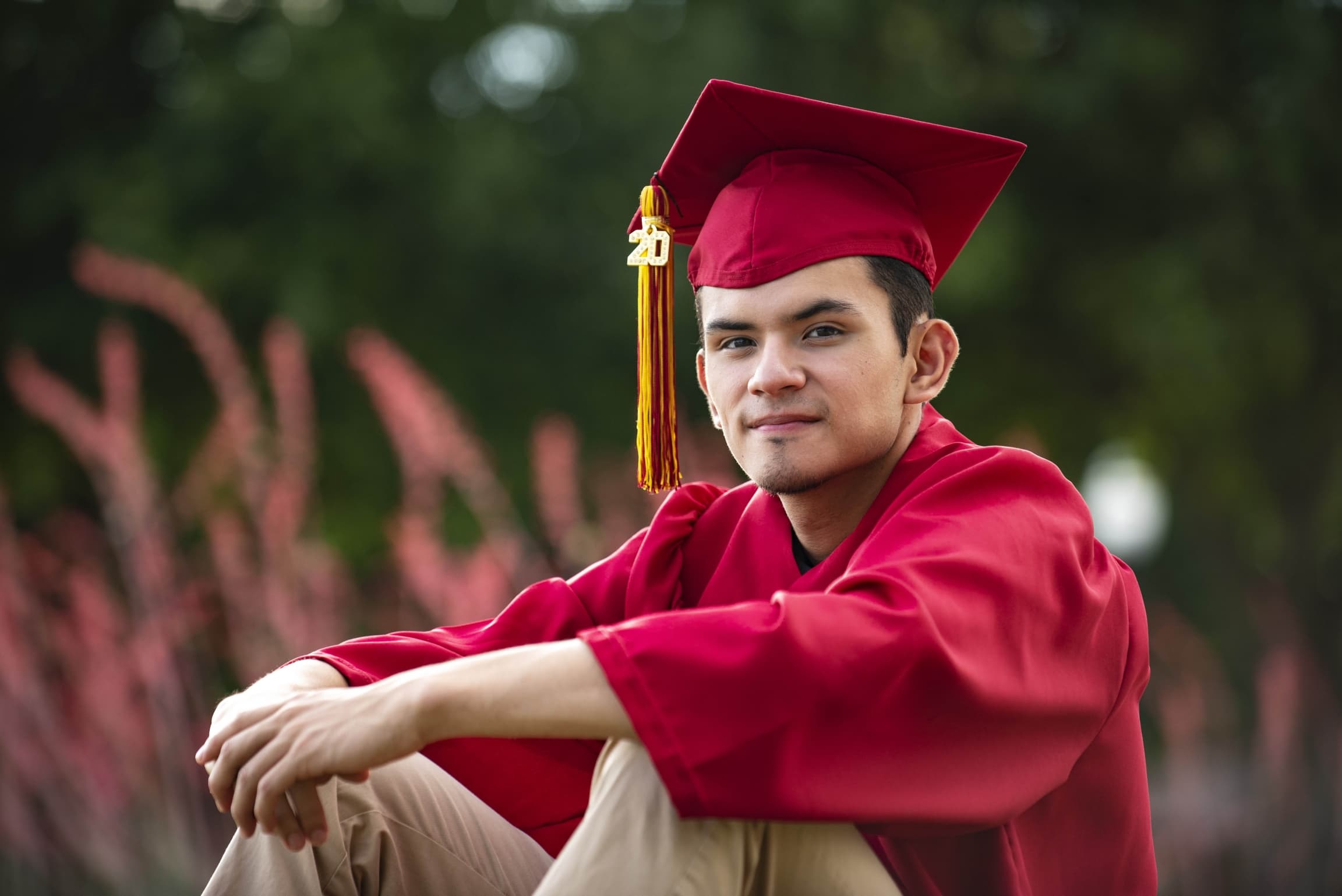 Un joven con gorra y birrete rojos posa para una foto