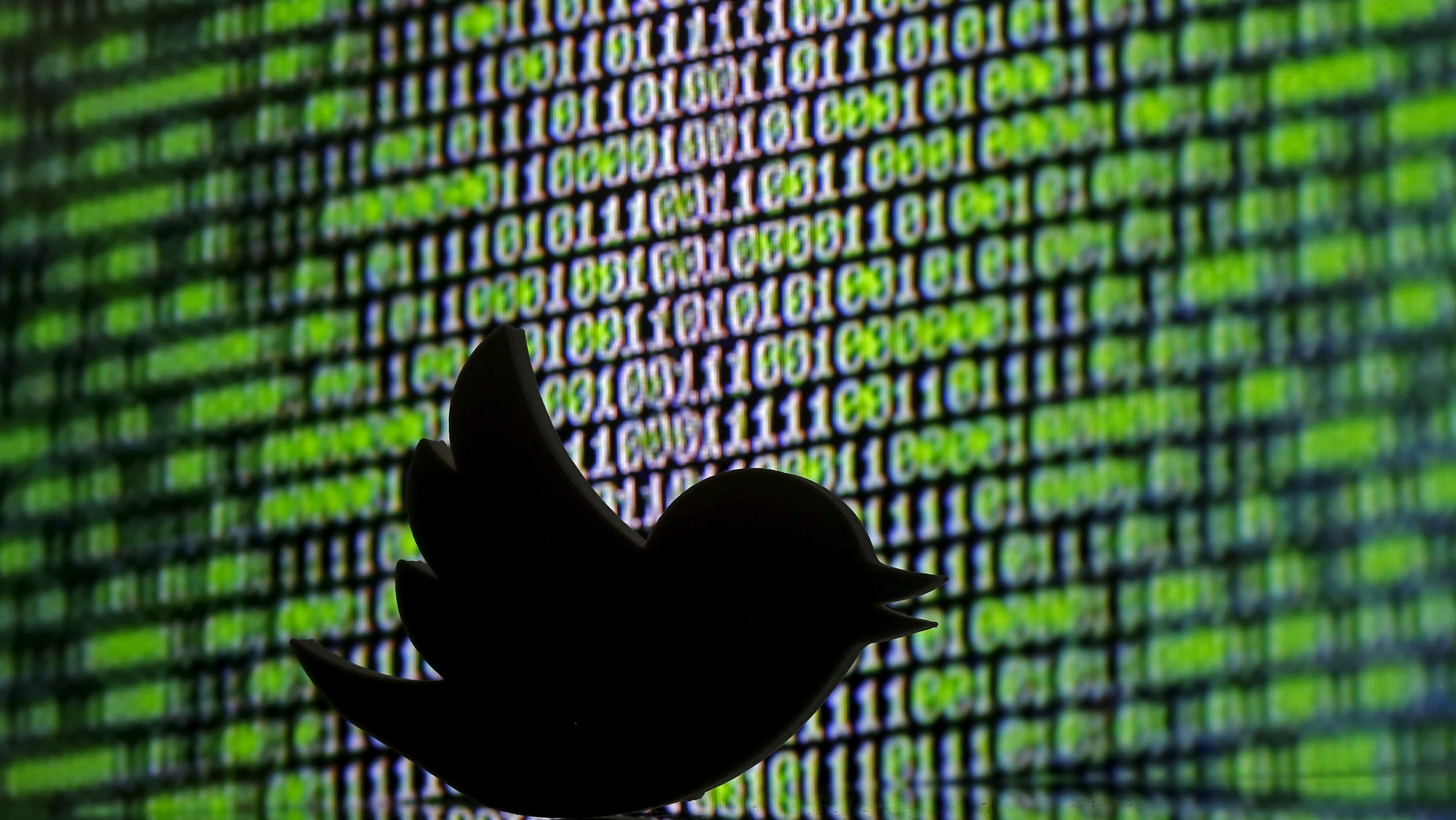 A Twitter logo seen in front of cyber code