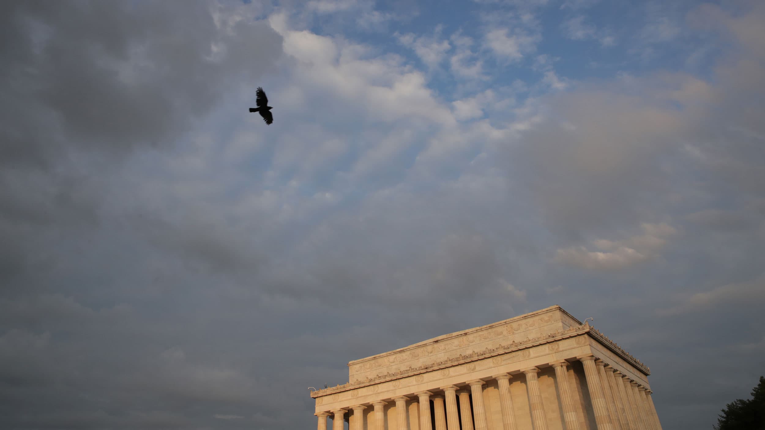 The Lincoln Memorial is shown with a colorful sunrise in the distance.