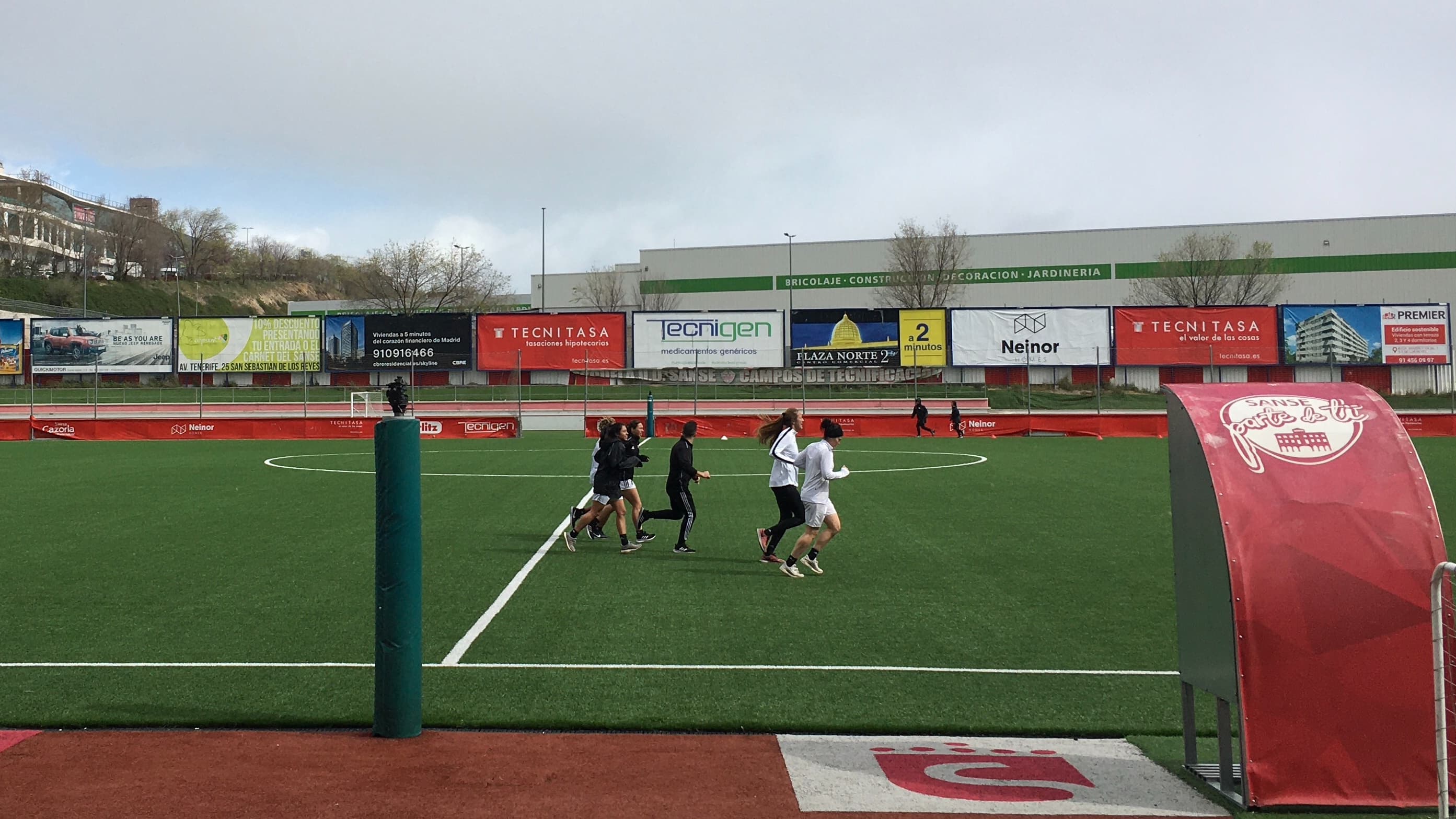 Women run on a soccer field