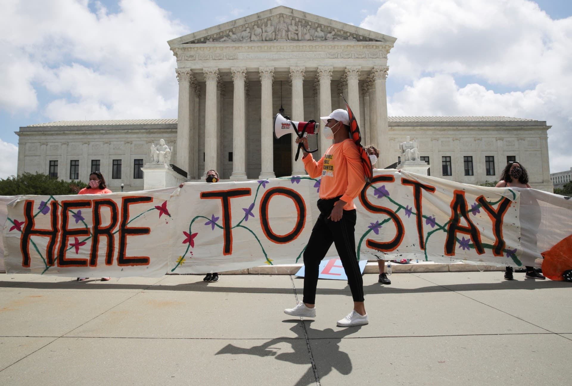 DACA supporters hold up banner in front of Supreme Court