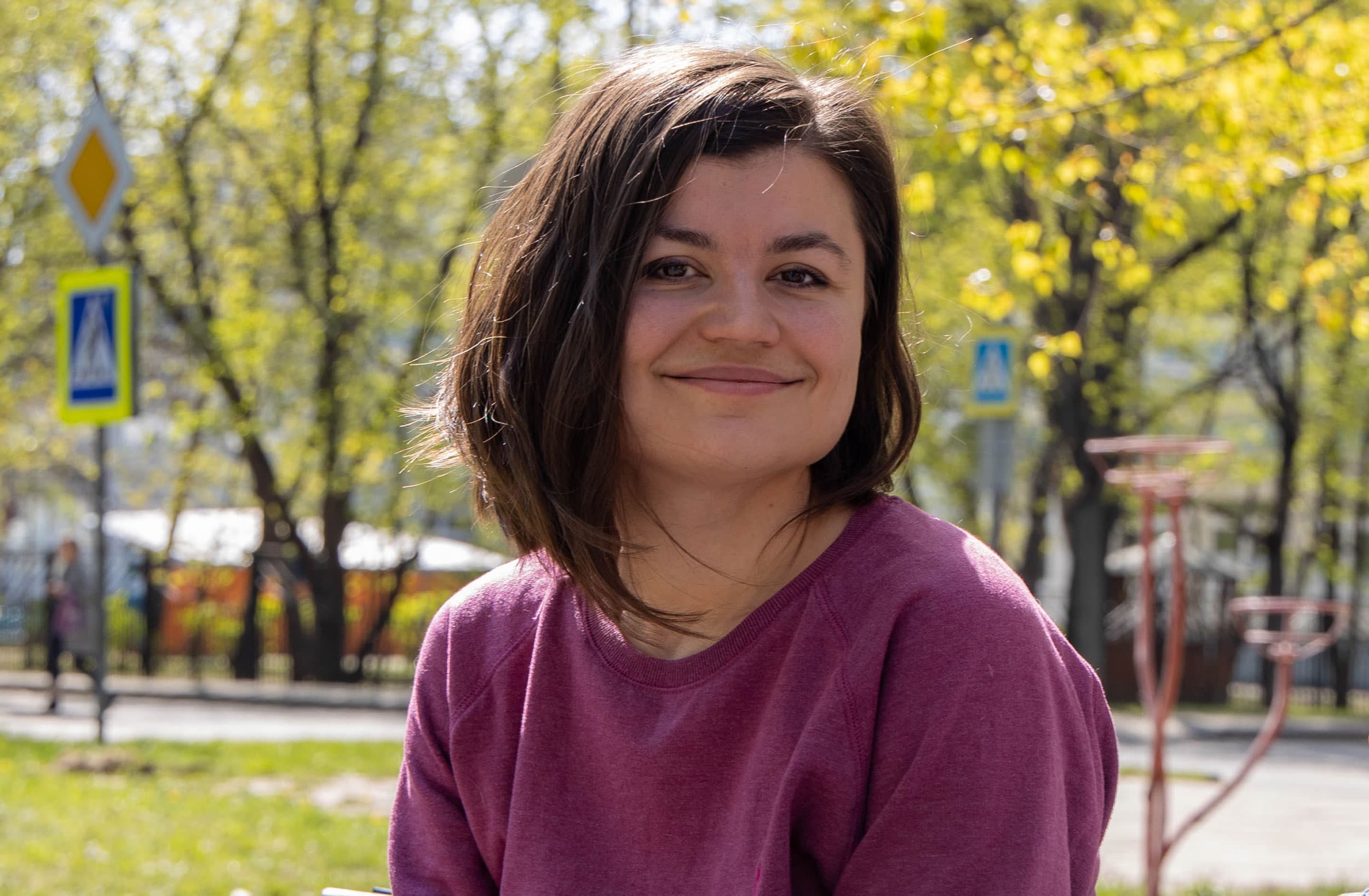 A young woman poses for a portrait in a park