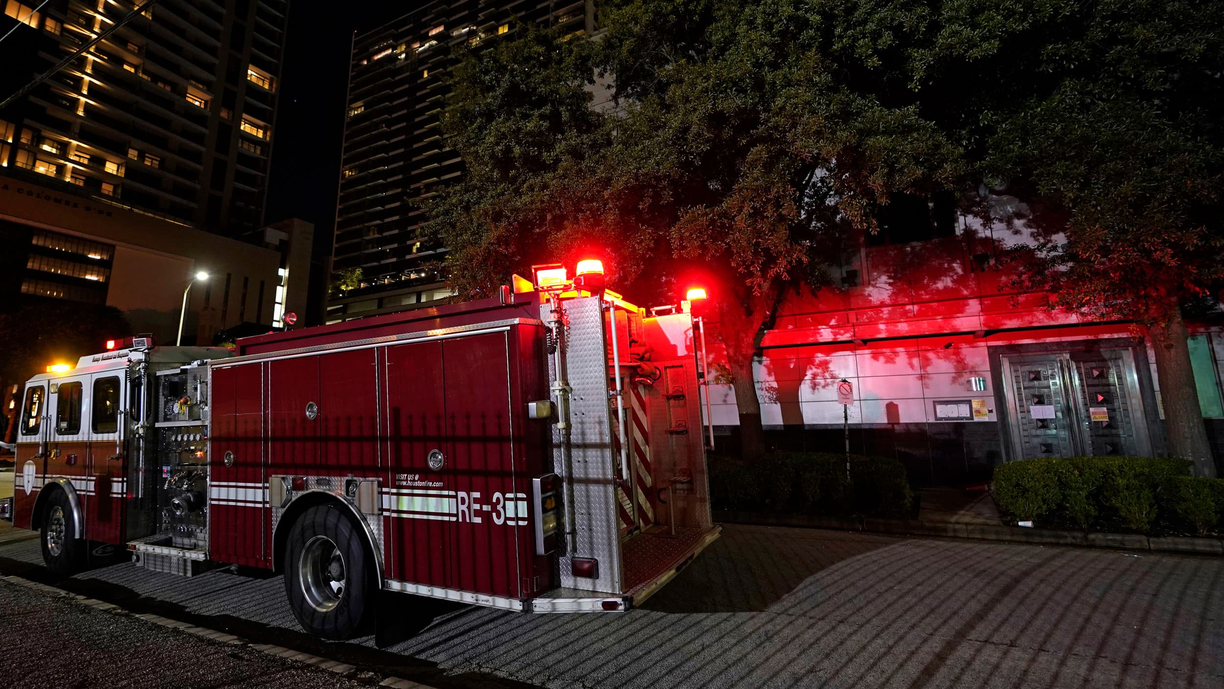 A car and an SUV are shown in blurred motion passing by the China Consulate General in Houston.