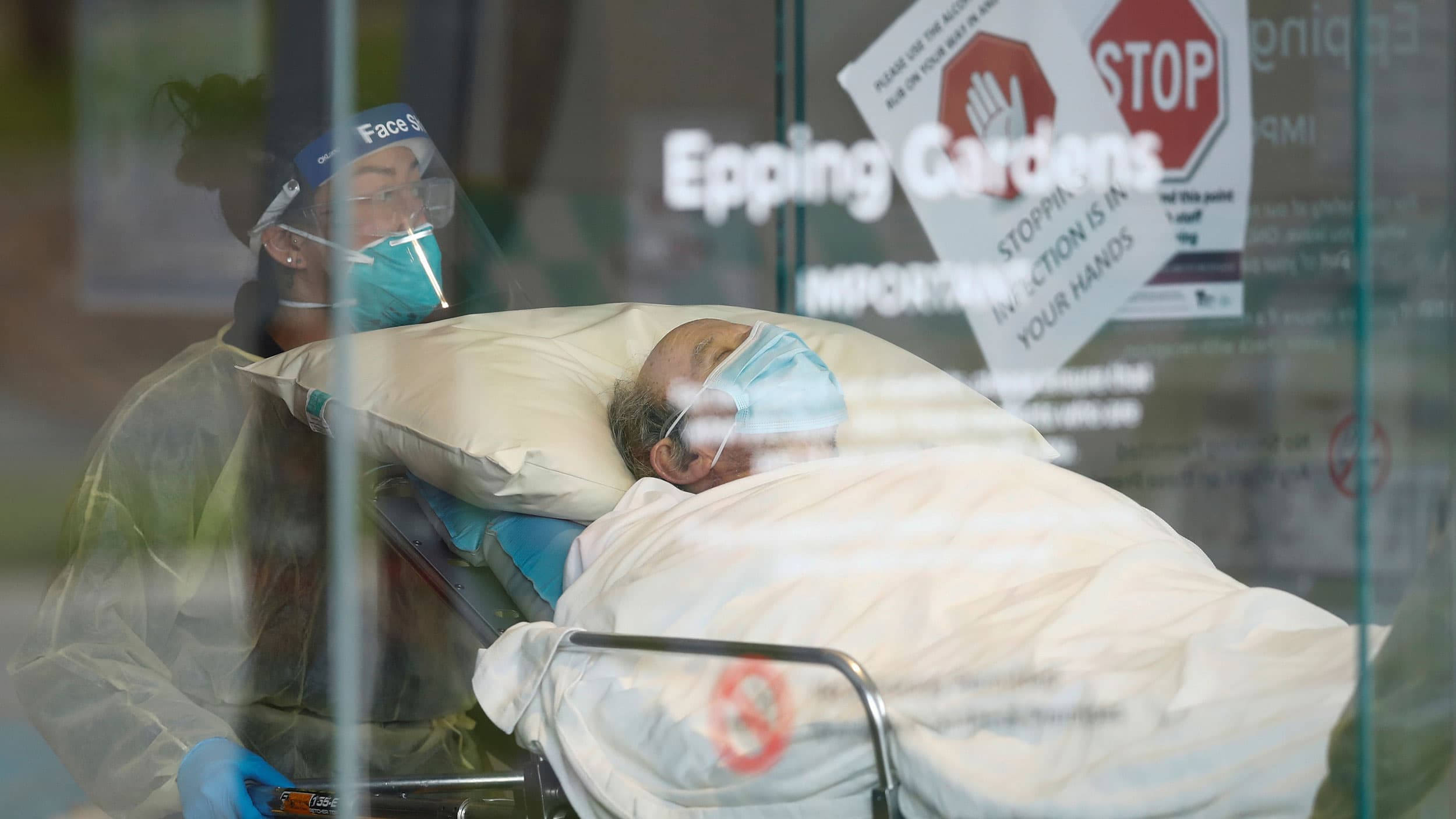 A man is shown laying in a gurney with a medical professional at the head.