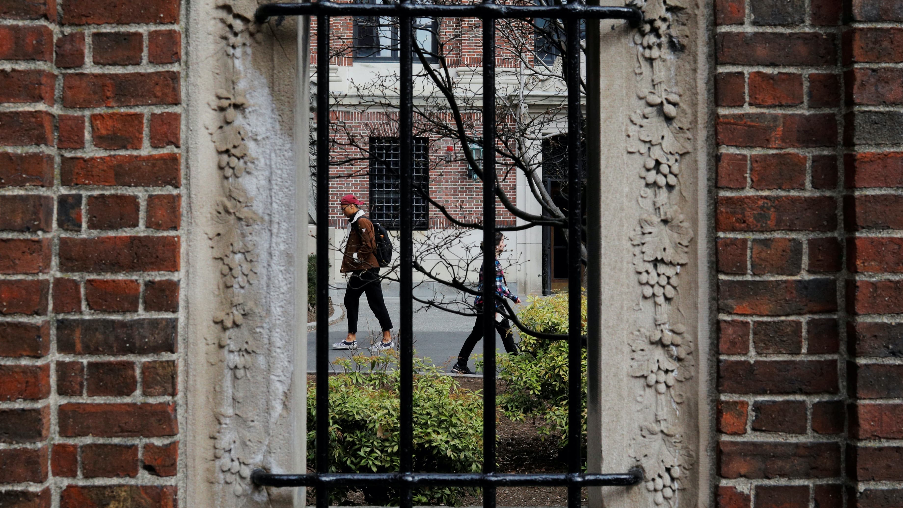 Two students walk through a college campus