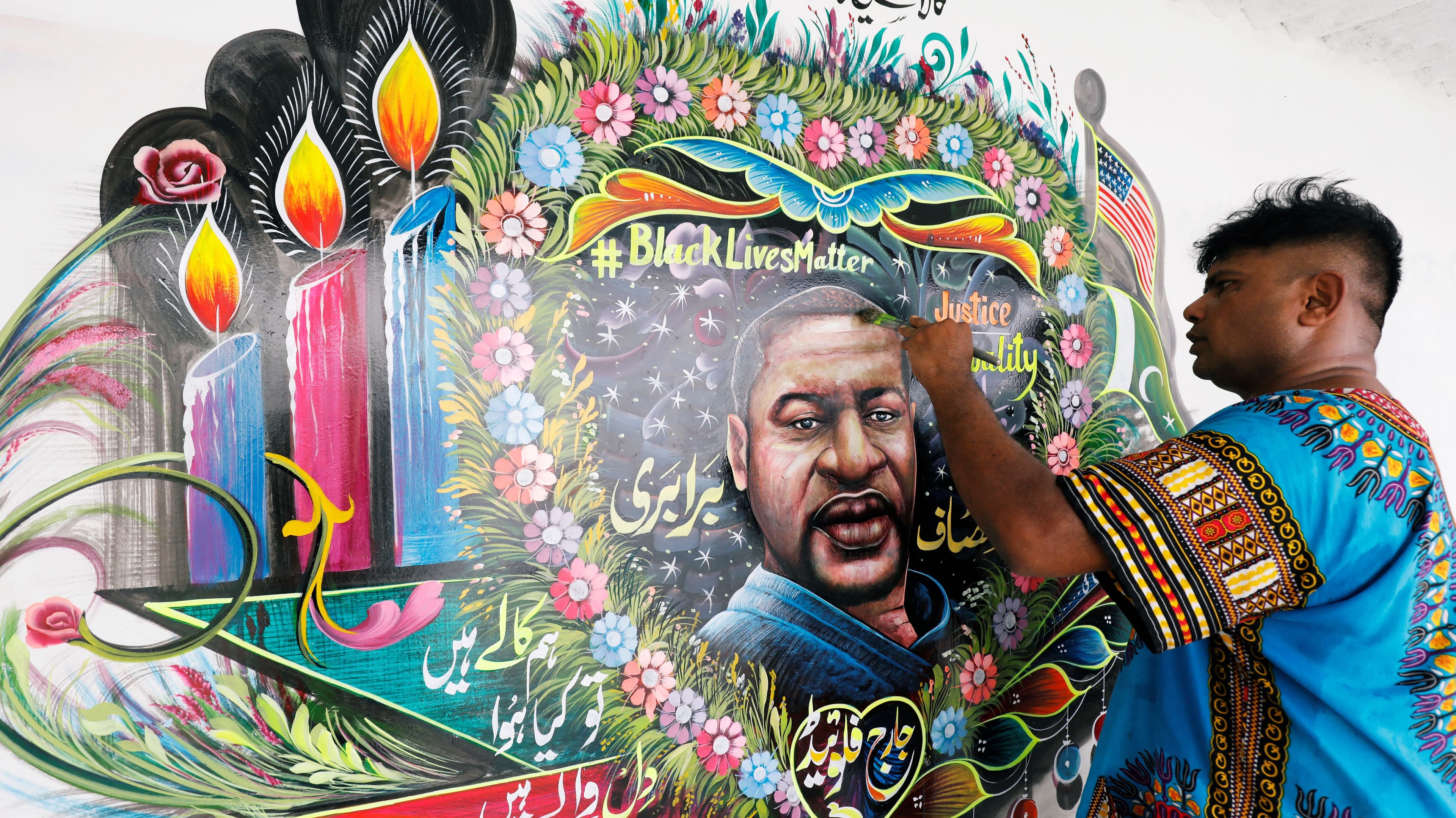 Pakistani truck-art painter Haider Ali, 40, touches up a mural depicting George Floyd in Karachi, Pakistan, June 12, 2020.