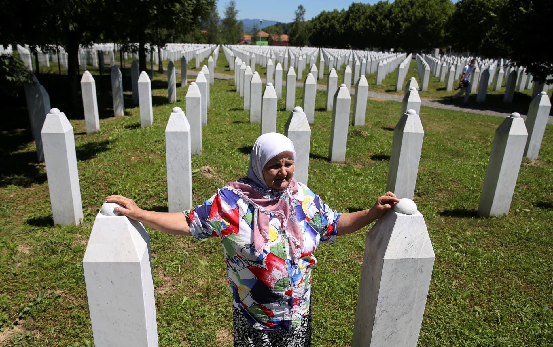 A woman stands at a memorial.