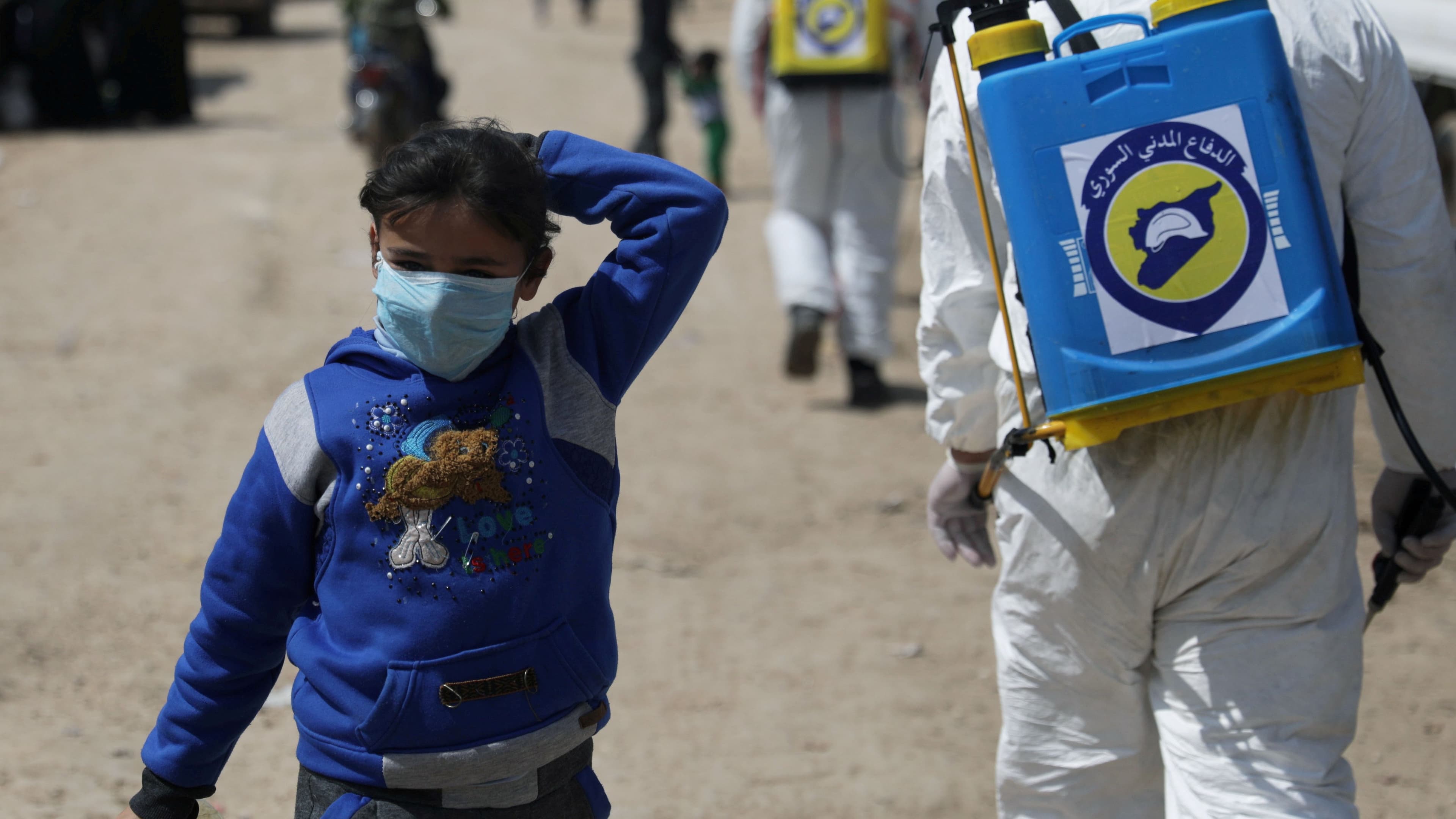 An internally displaced Syrian girl wears a face mask as members of the Syrian Civil defence sanitize the Bab al-Nour internally displaced persons camp, to prevent the spread of the coronavirus disease (COVID-19) in Azaz, Syria, March 26, 2020.