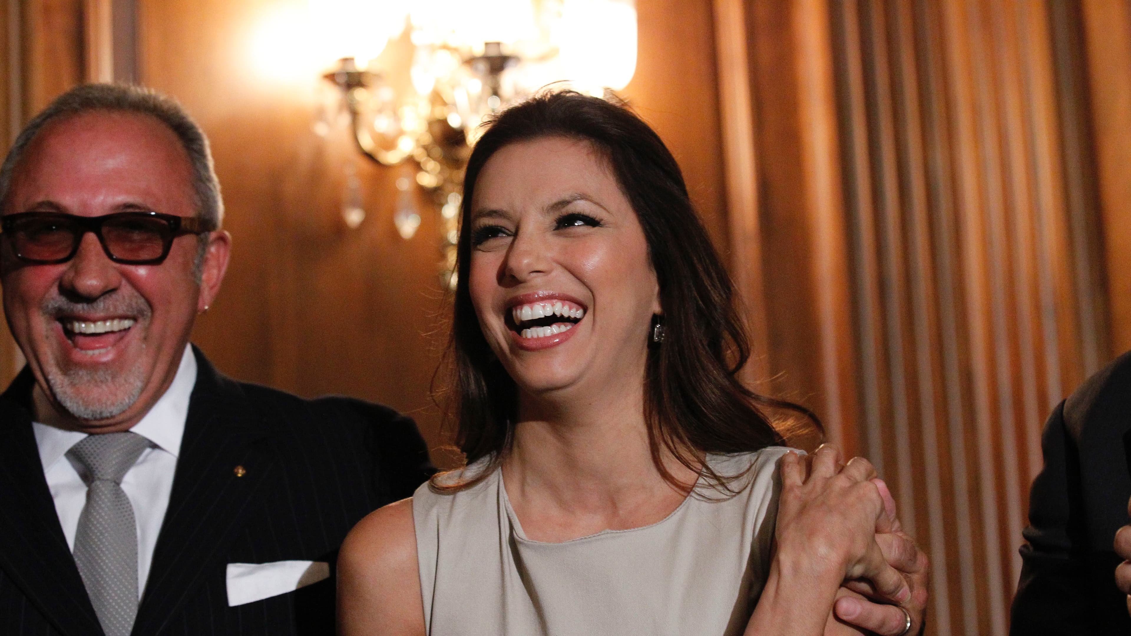 A woman and man wearing elegant evening wear laugh