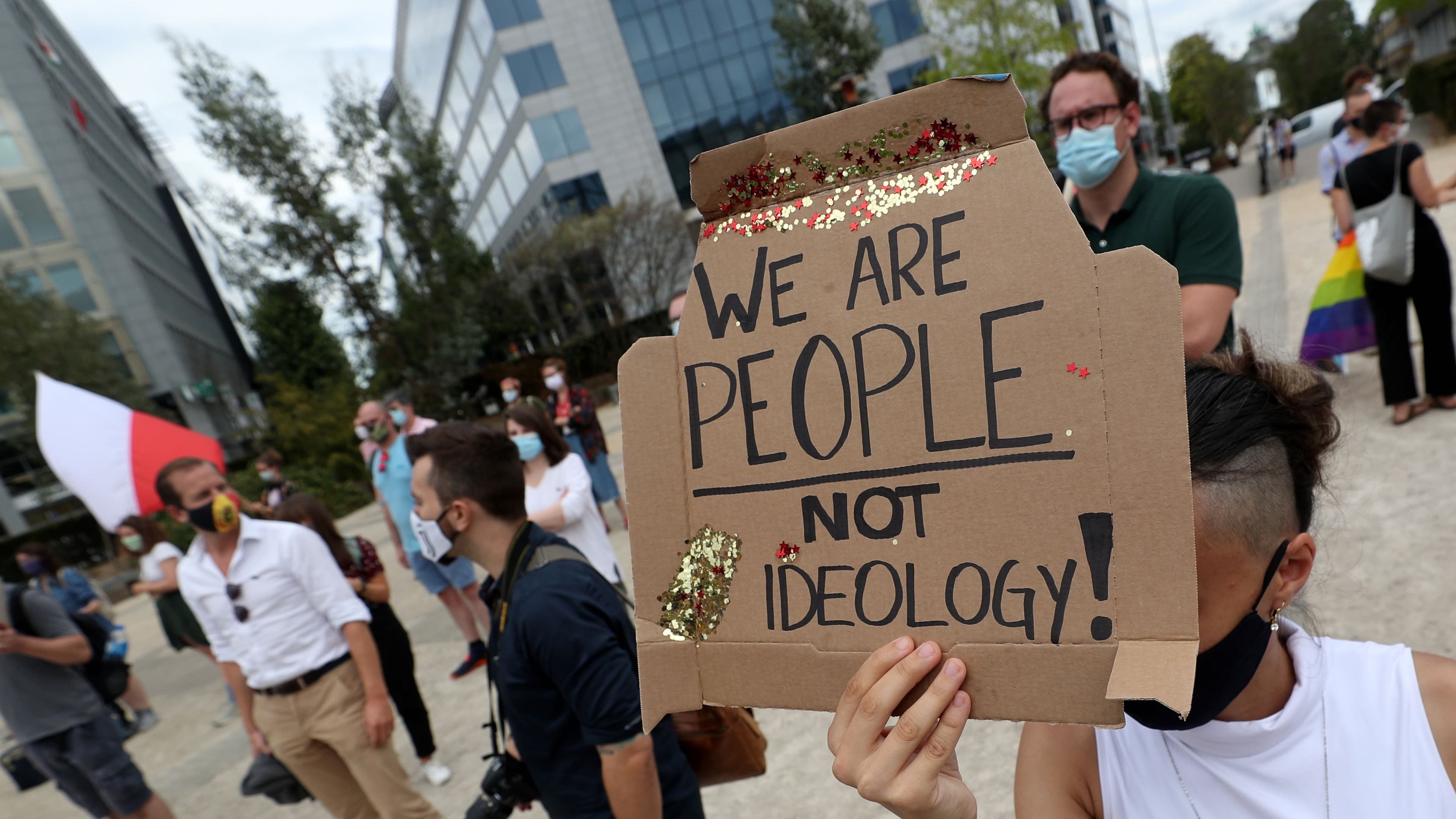 A demonstrator holds a sign as people gather outside the European Union institutions to rally in solidarity with Poland's LGBT community, in Brussels, Aug. 19, 2020.